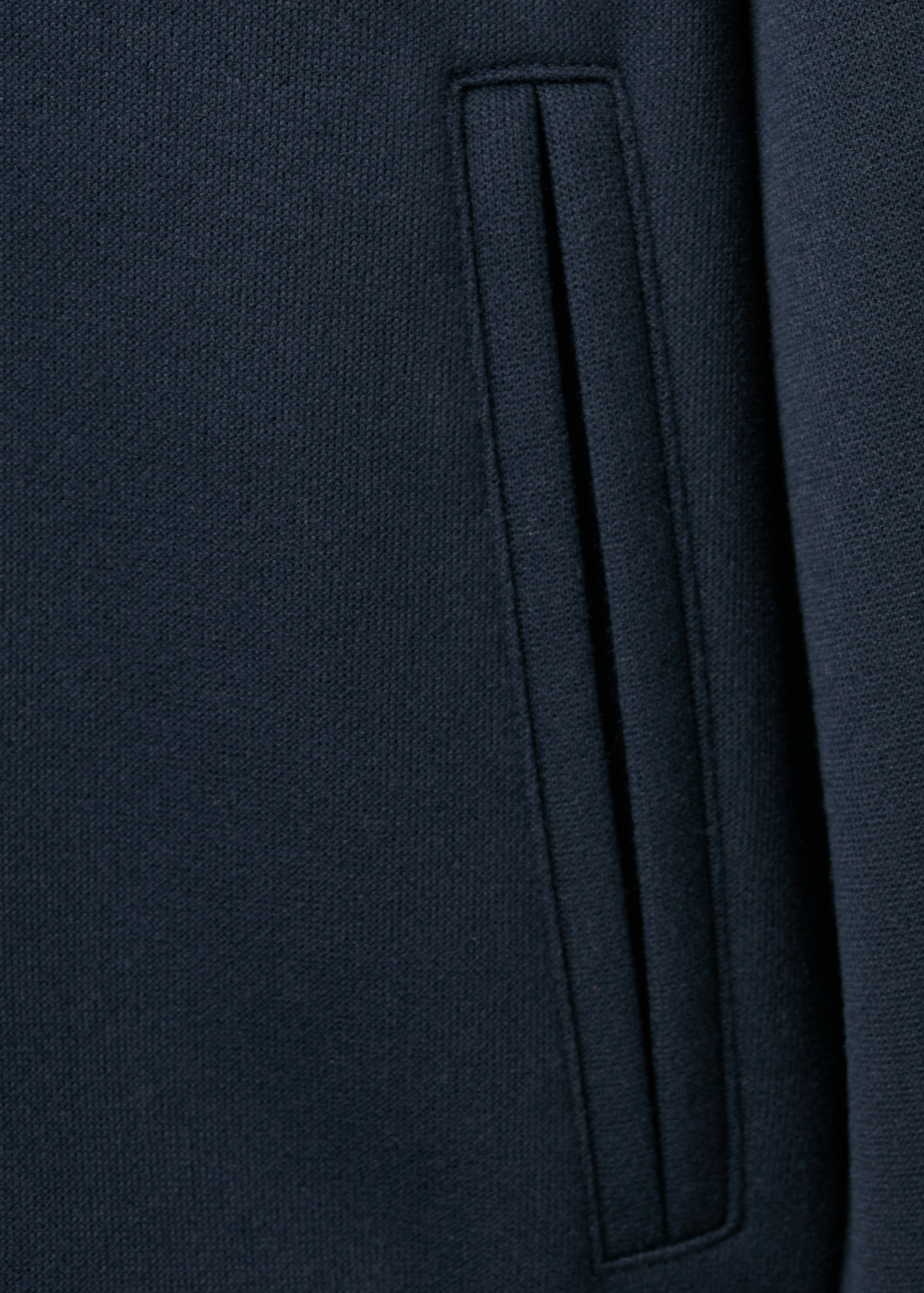 Close-up of a navy blue sweatshirt pocket detail.
