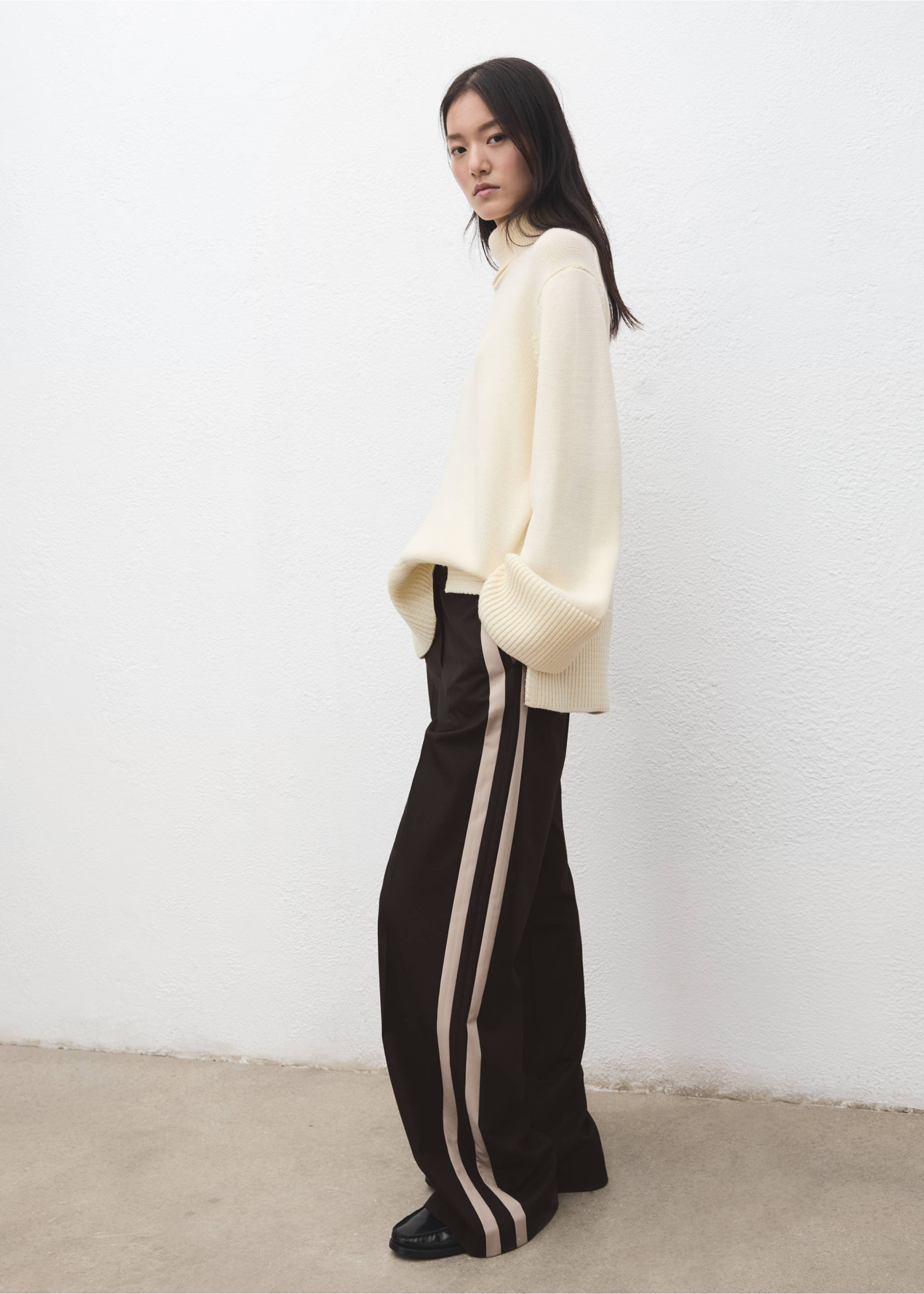Black wide-leg trousers with contrasting side stripes, styled with a cream turtleneck sweater., Chocolate. Ref: 27021296-00.