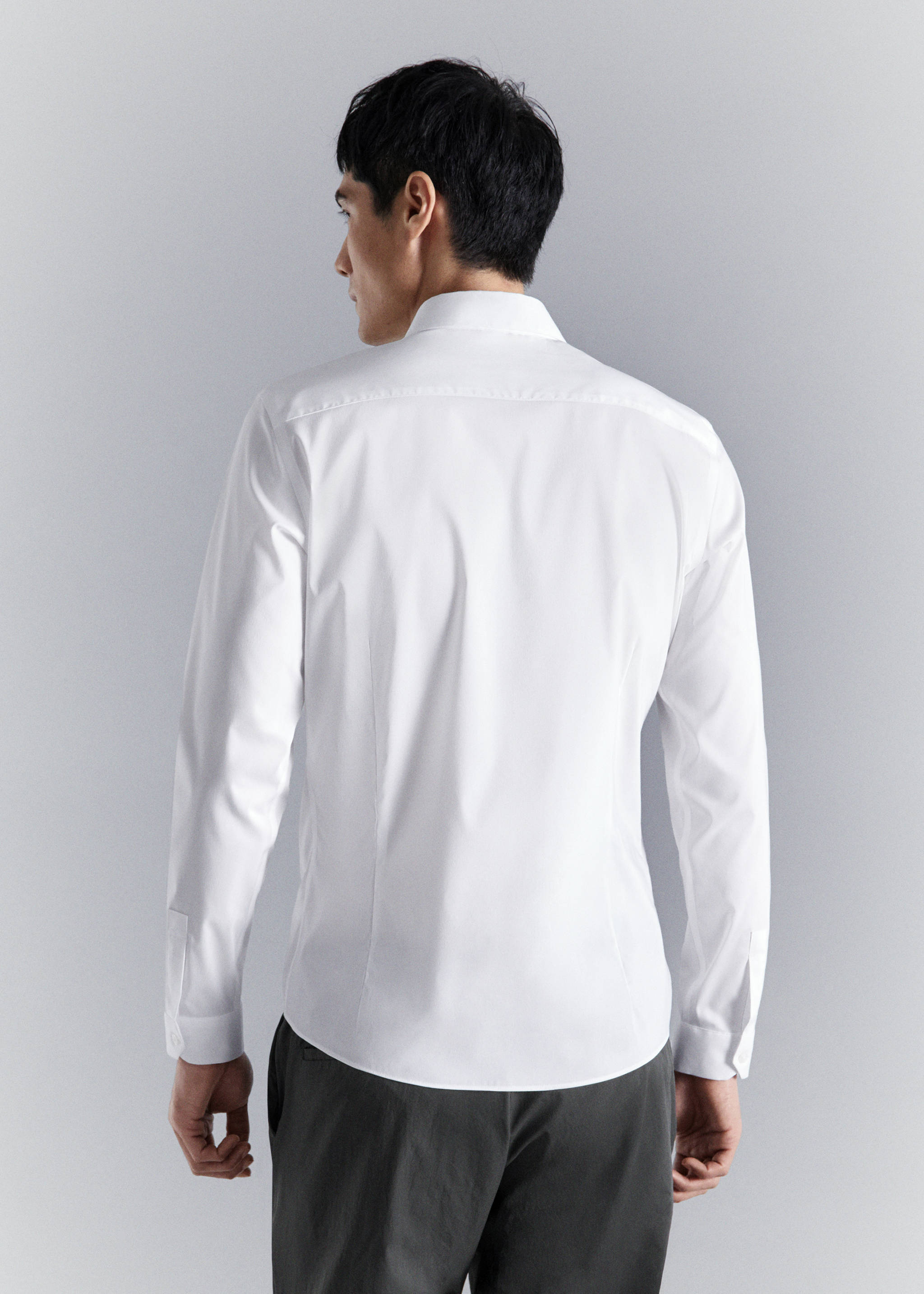 White long-sleeved shirt shown from the back, featuring a classic collar and fitted silhouette.