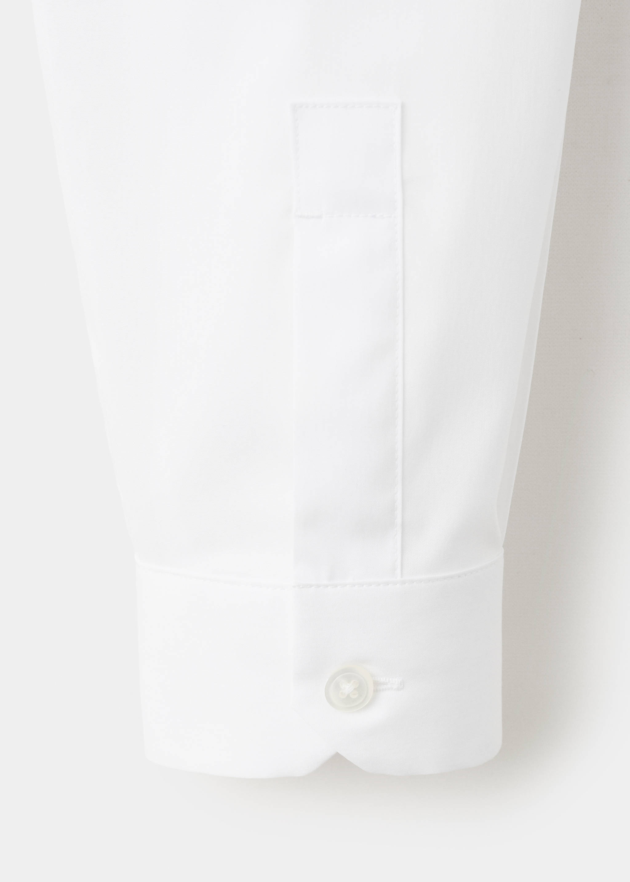 Close-up of a white shirt sleeve cuff with a single button.