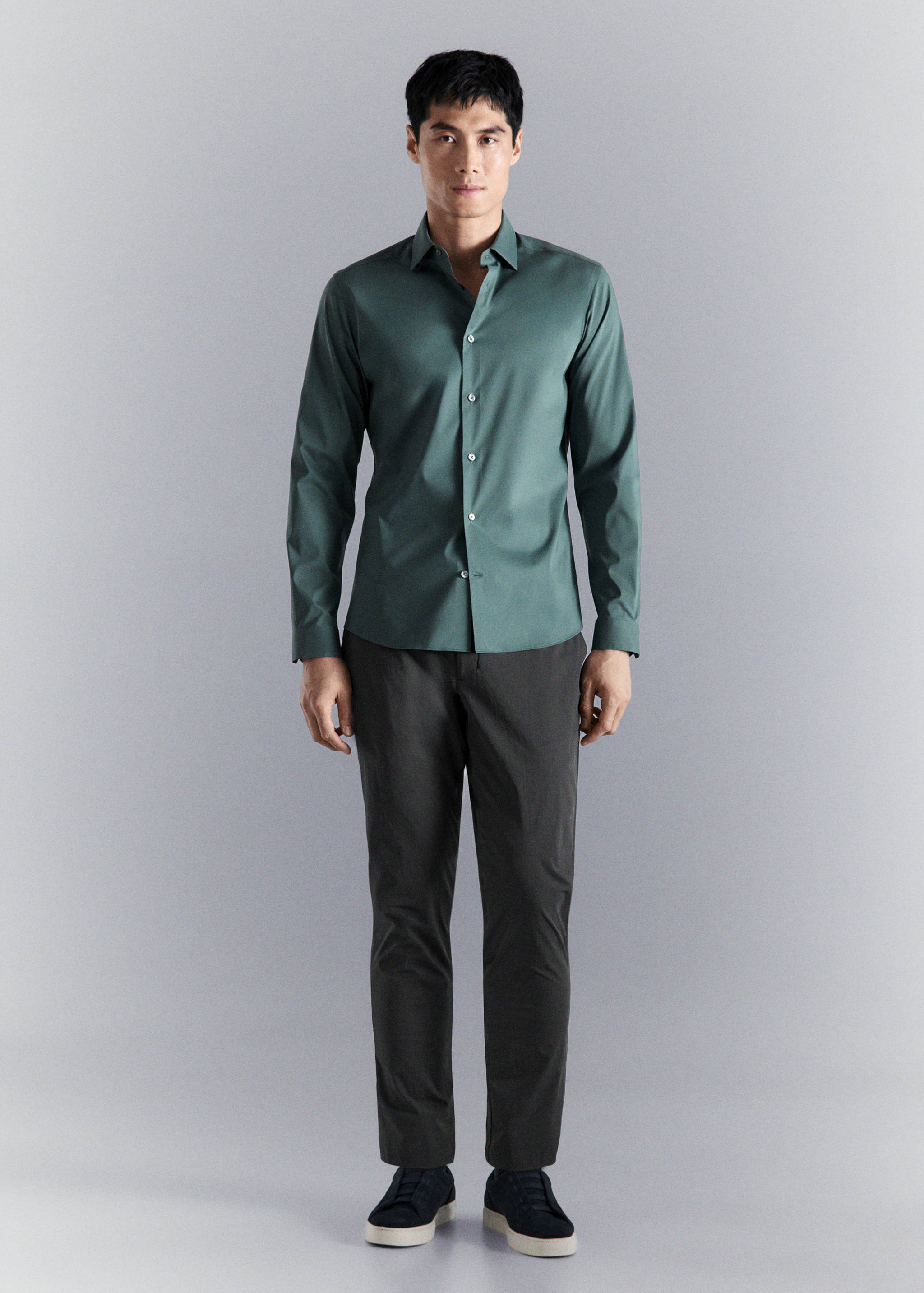 Dark green long-sleeved shirt with a classic collar and front button fastening.