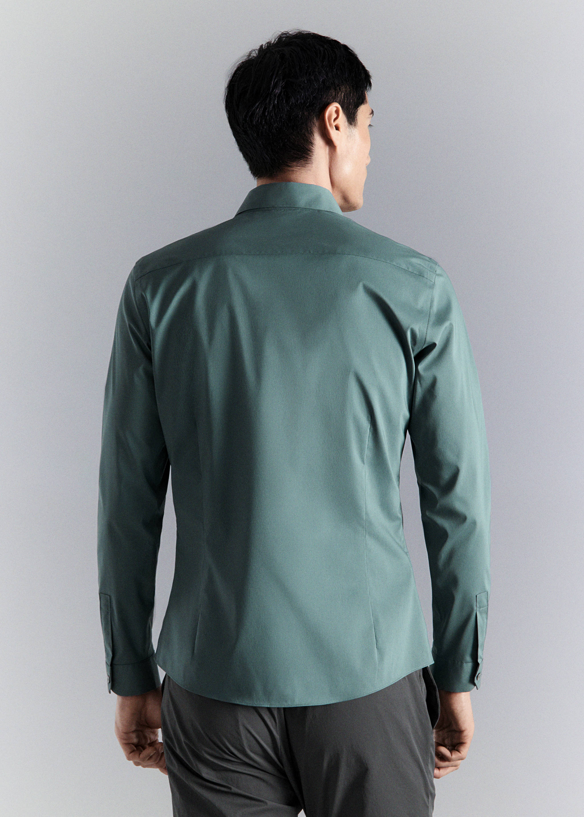 Back view of a green long-sleeved shirt with a classic collar.