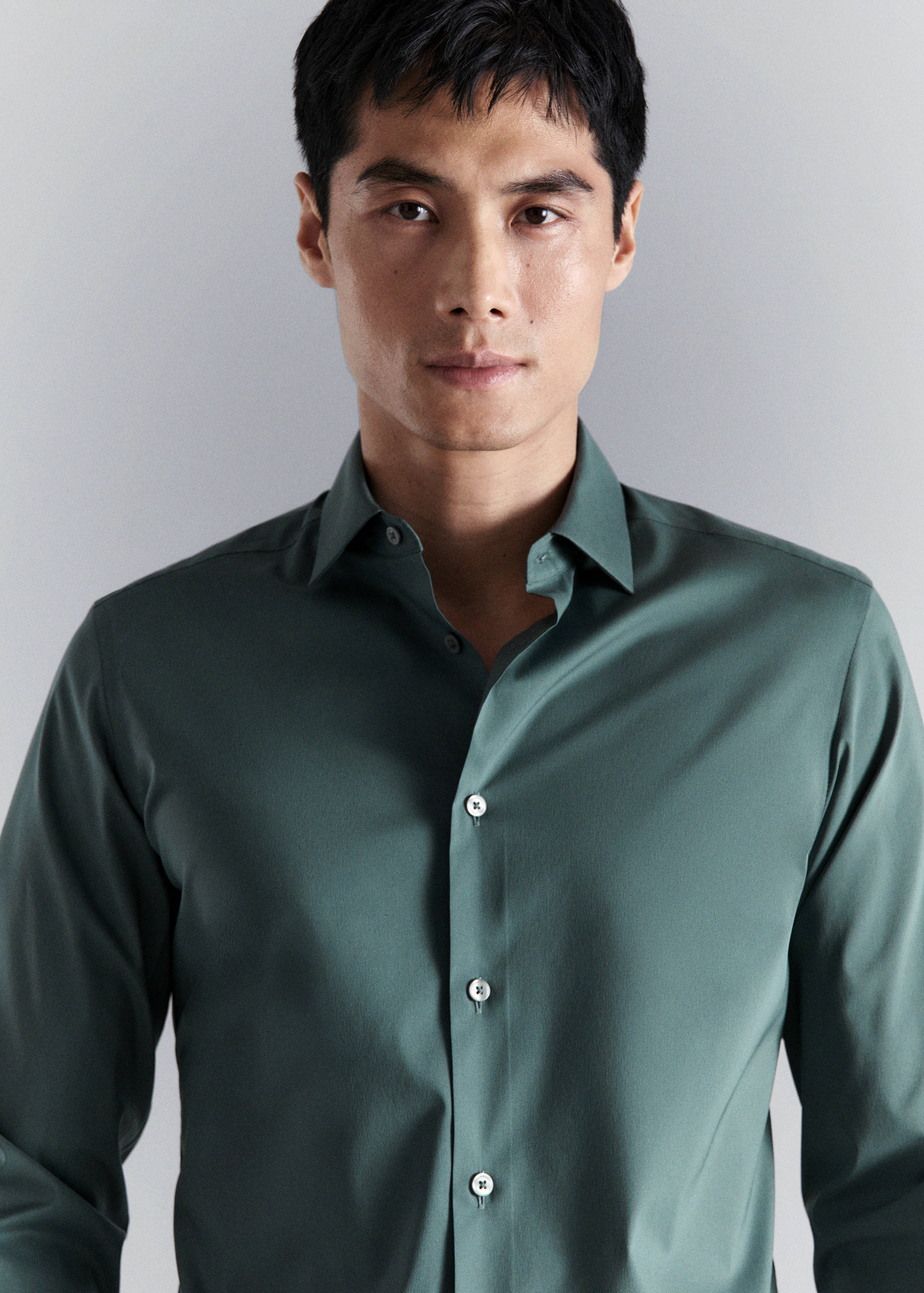 Close-up of a dark green long-sleeved shirt with a classic collar.