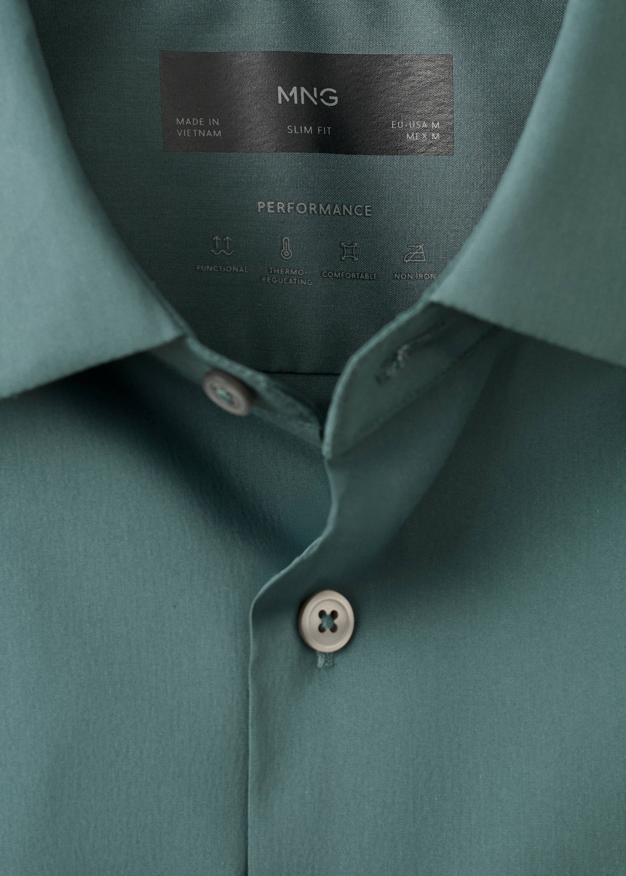 Close-up of a dark green slim fit shirt collar and button detail.