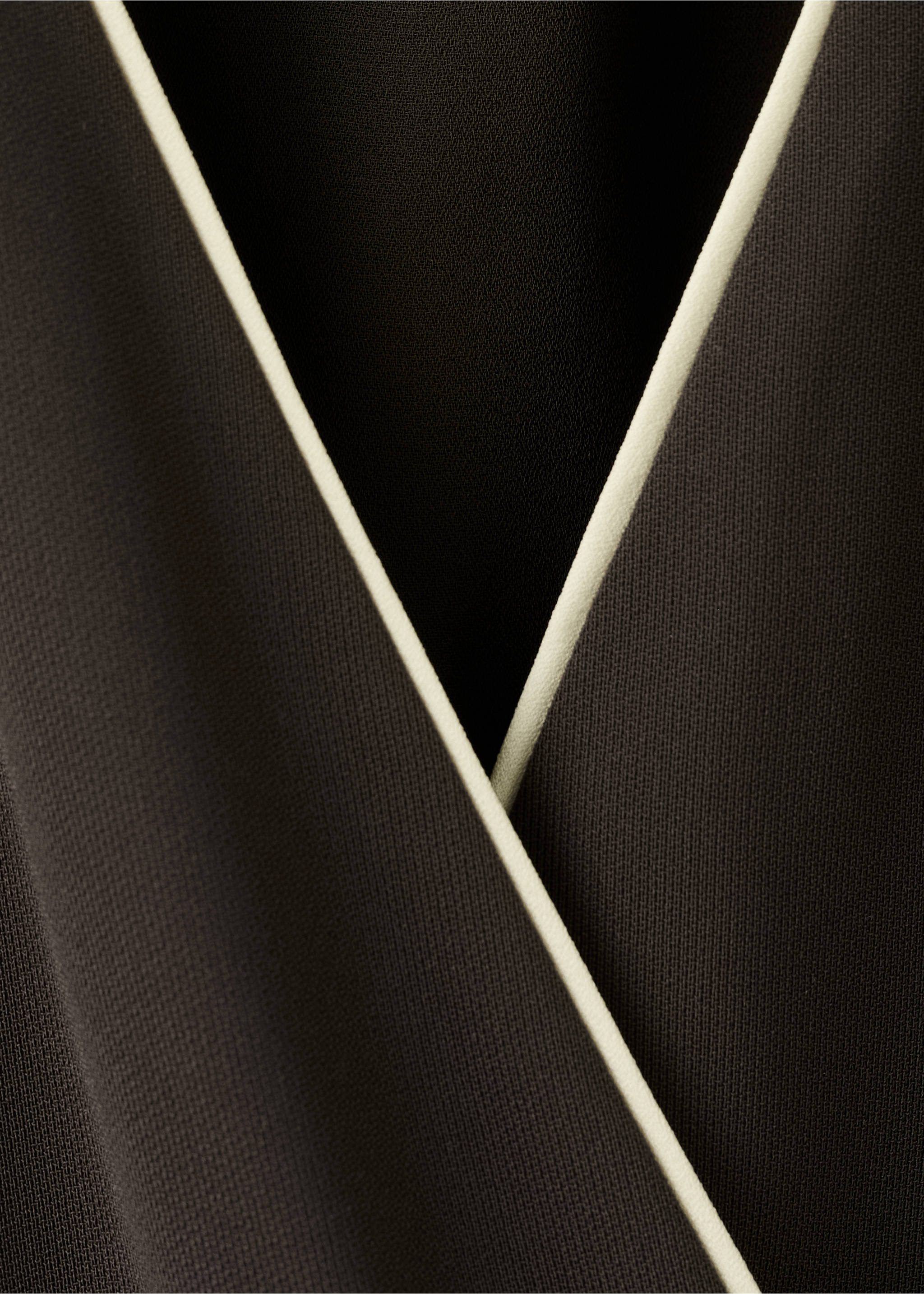 Close-up of black jumpsuit fabric with contrasting white piping., Chocolate. Ref: 27025834-00.