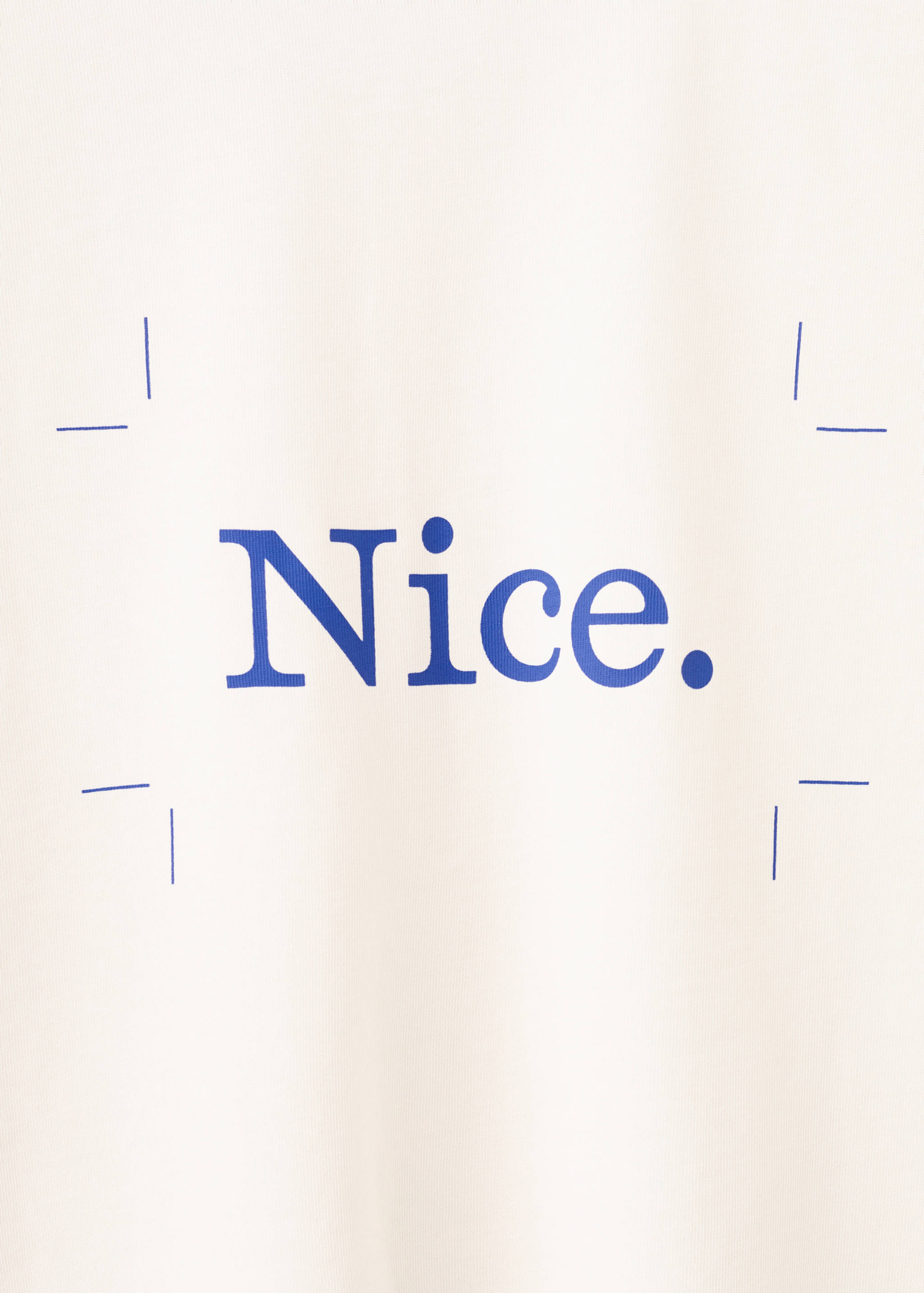Close-up of a white T-shirt with blue 'Nice.' text and framing brackets.