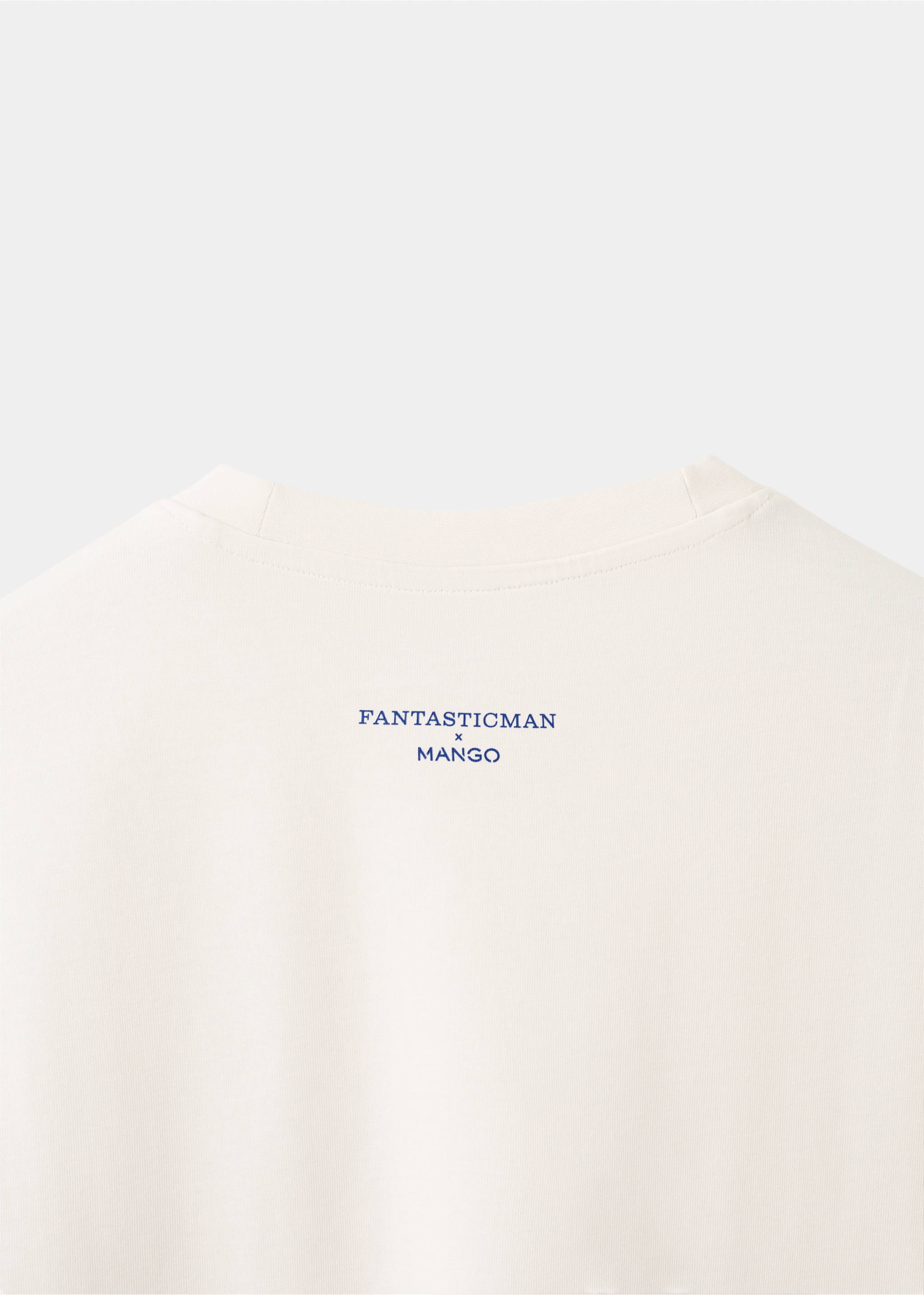 Close-up of an off-white T-shirt fabric showing the navy collaboration print on the upper back., Off White. Ref: 27025993-00.