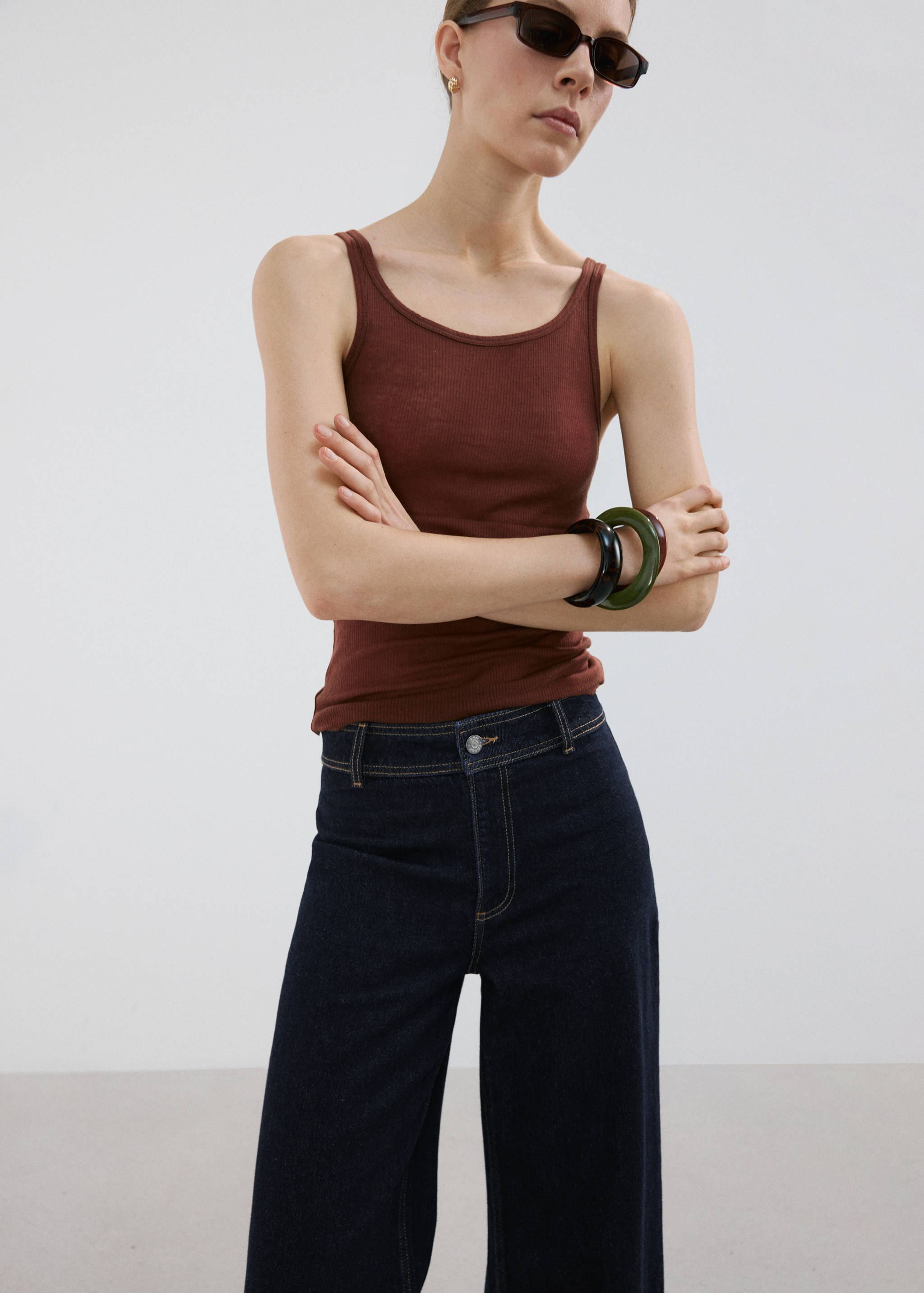 Dark blue jeans with contrast topstitching and a button closure.