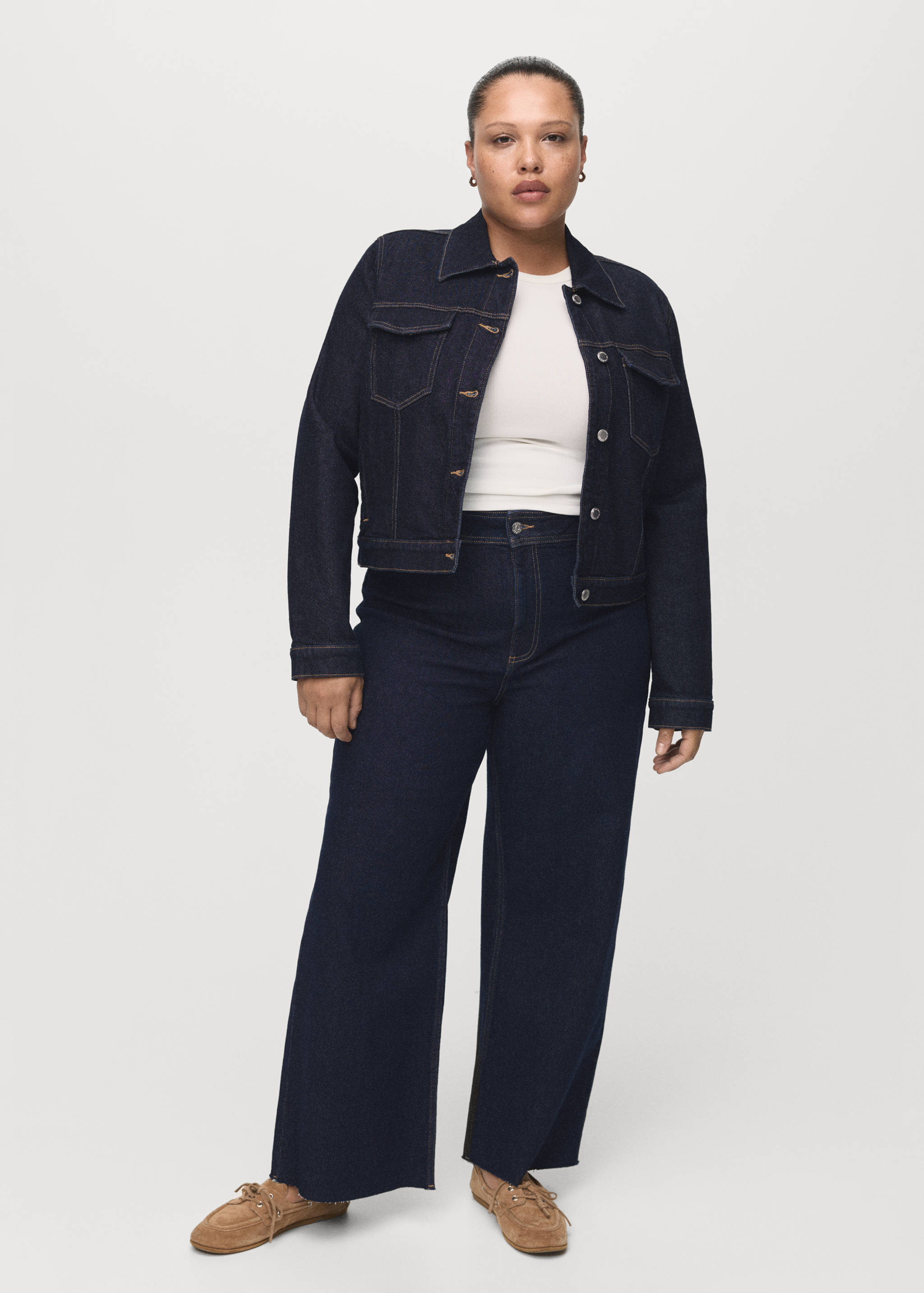 Dark blue denim jacket with contrast stitching, worn with matching wide-leg trousers.