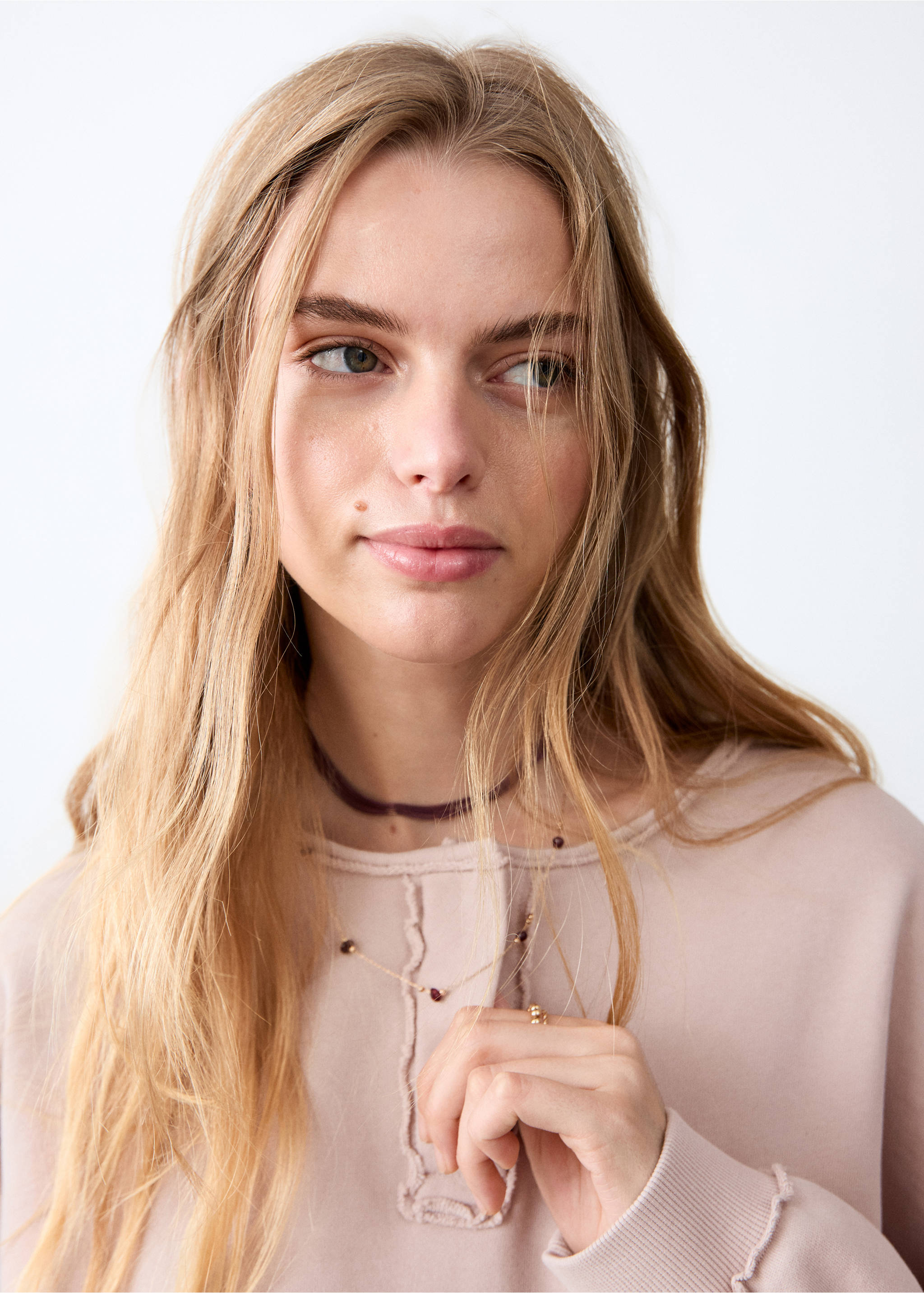 Light pink sweatshirt with raw-edge details and ribbed cuffs, close-up face view., Pink. Ref: 27031517-00.