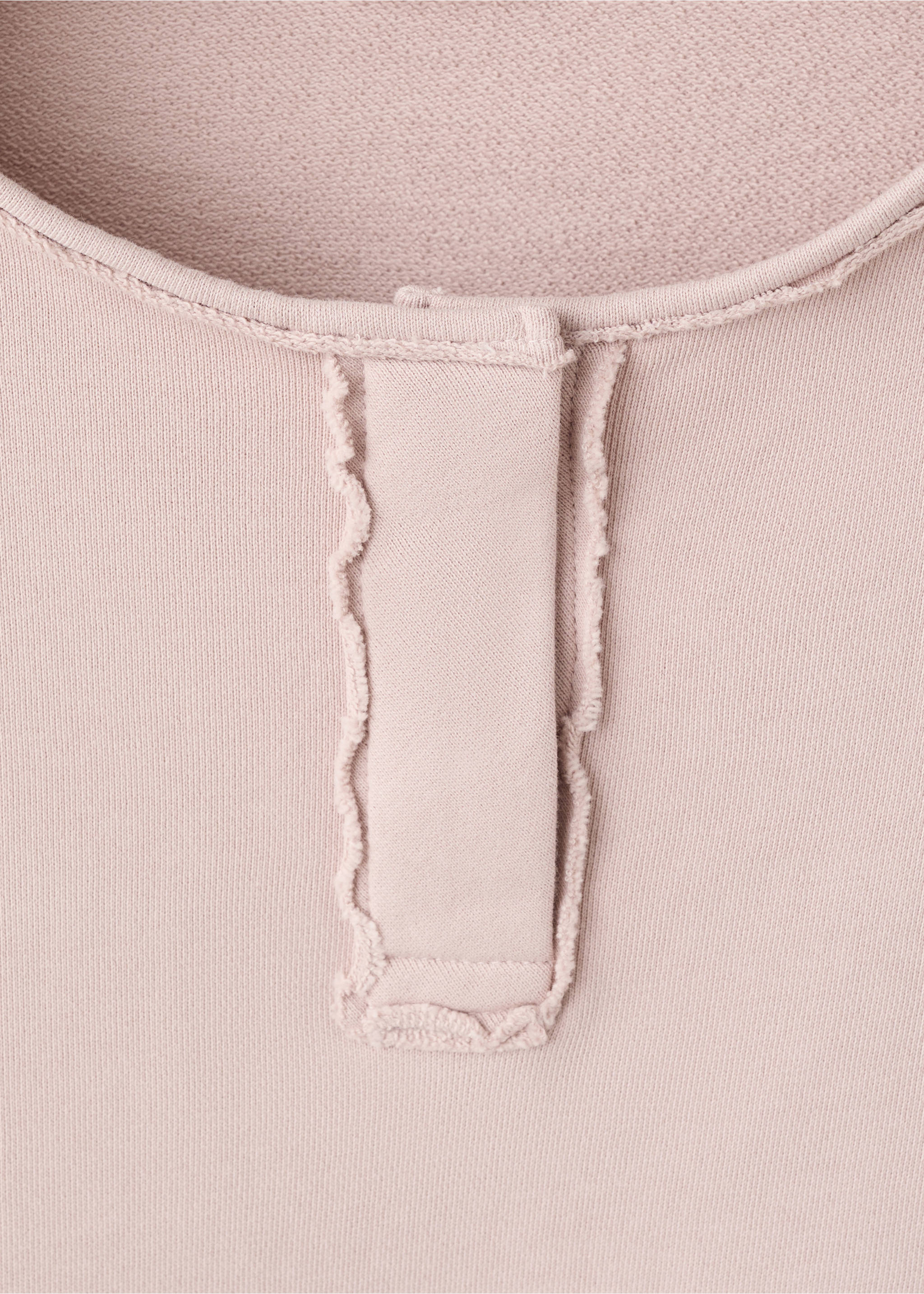 Close-up of a pale pink sweatshirt neckline featuring a raw-edge placket detail., Pink. Ref: 27031517-00.