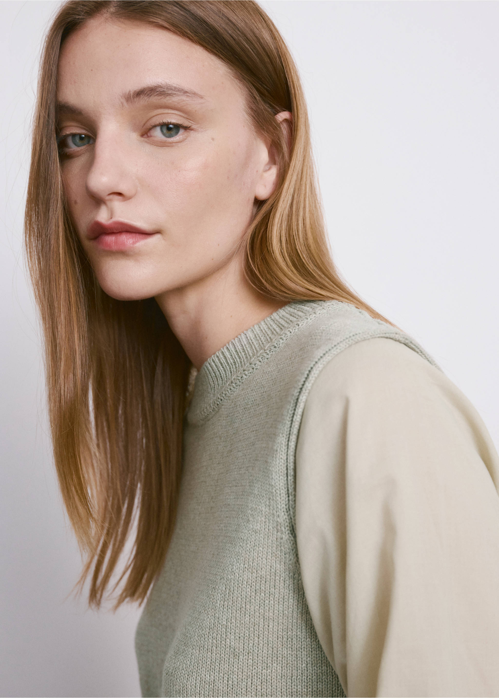 Close-up of a light green knit sleeveless jersey with a ribbed round neckline, layered over a shirt., Aqua Green. Ref: 27034093-00.