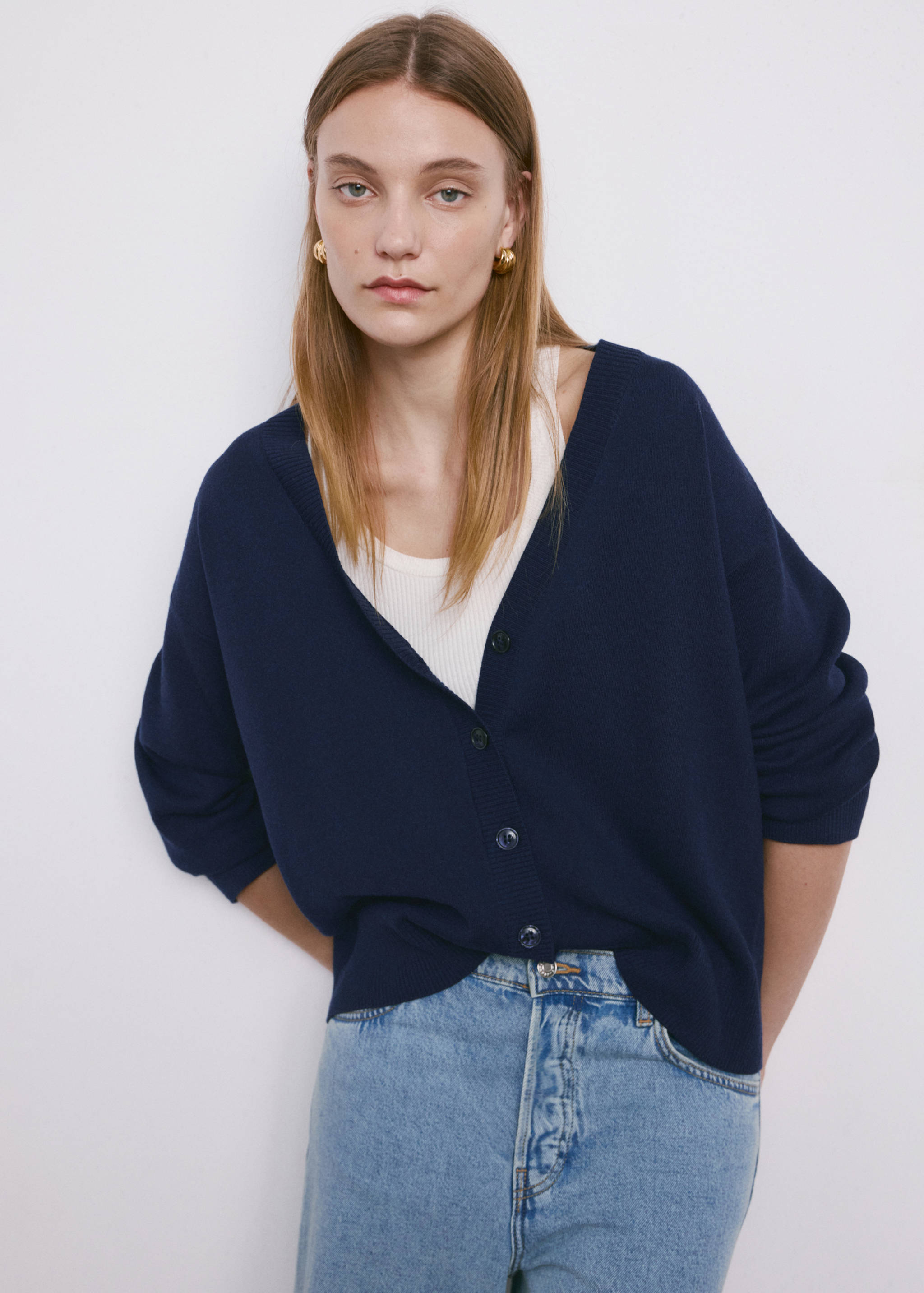 Navy blue V-neck cardigan with long sleeves and front button fastening.
