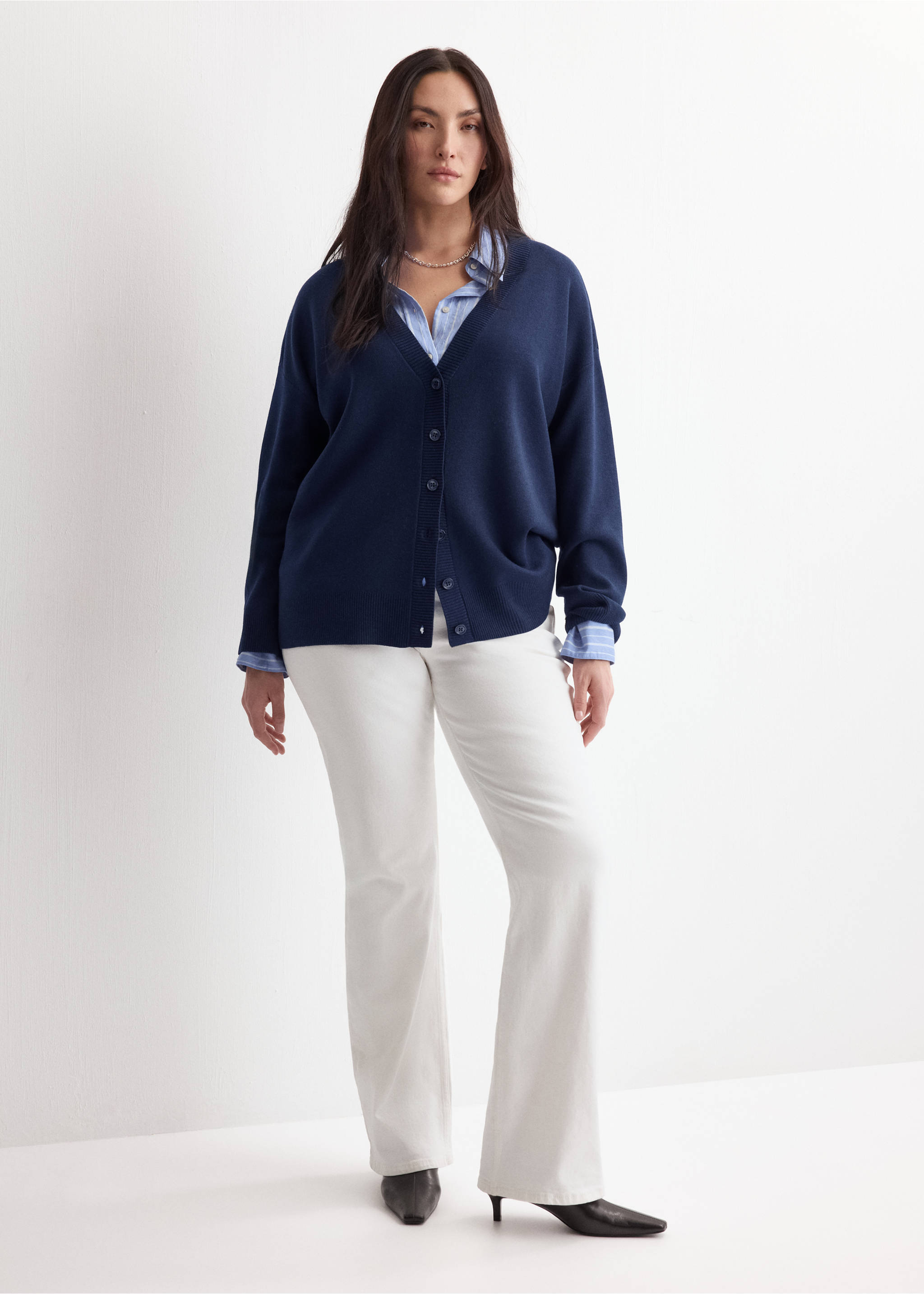 Navy blue V-neck button-down cardigan worn with a striped shirt and white trousers., Dark Navy. Ref: 27034774-00.