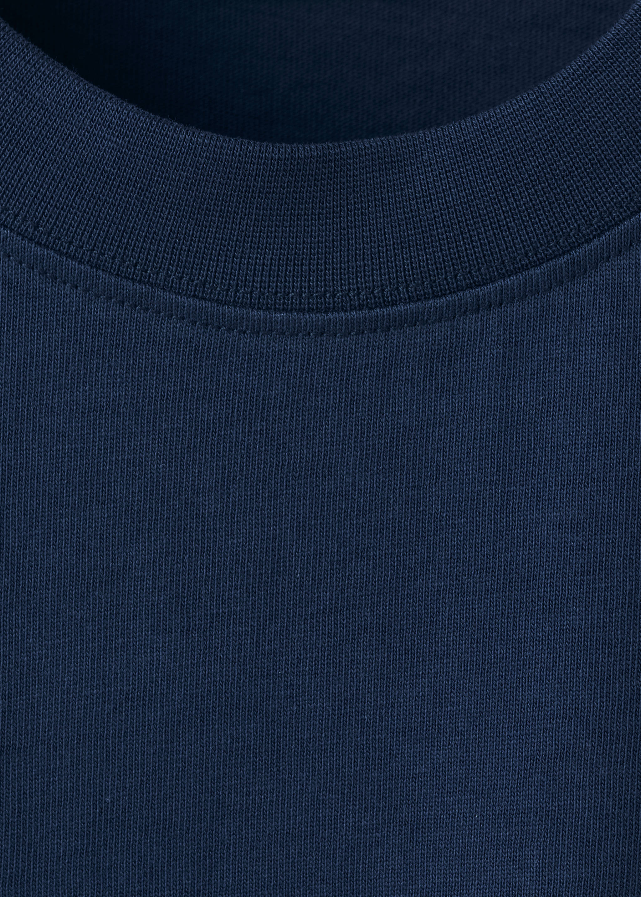 Close-up of navy blue t-shirt fabric and ribbed crew neckline.