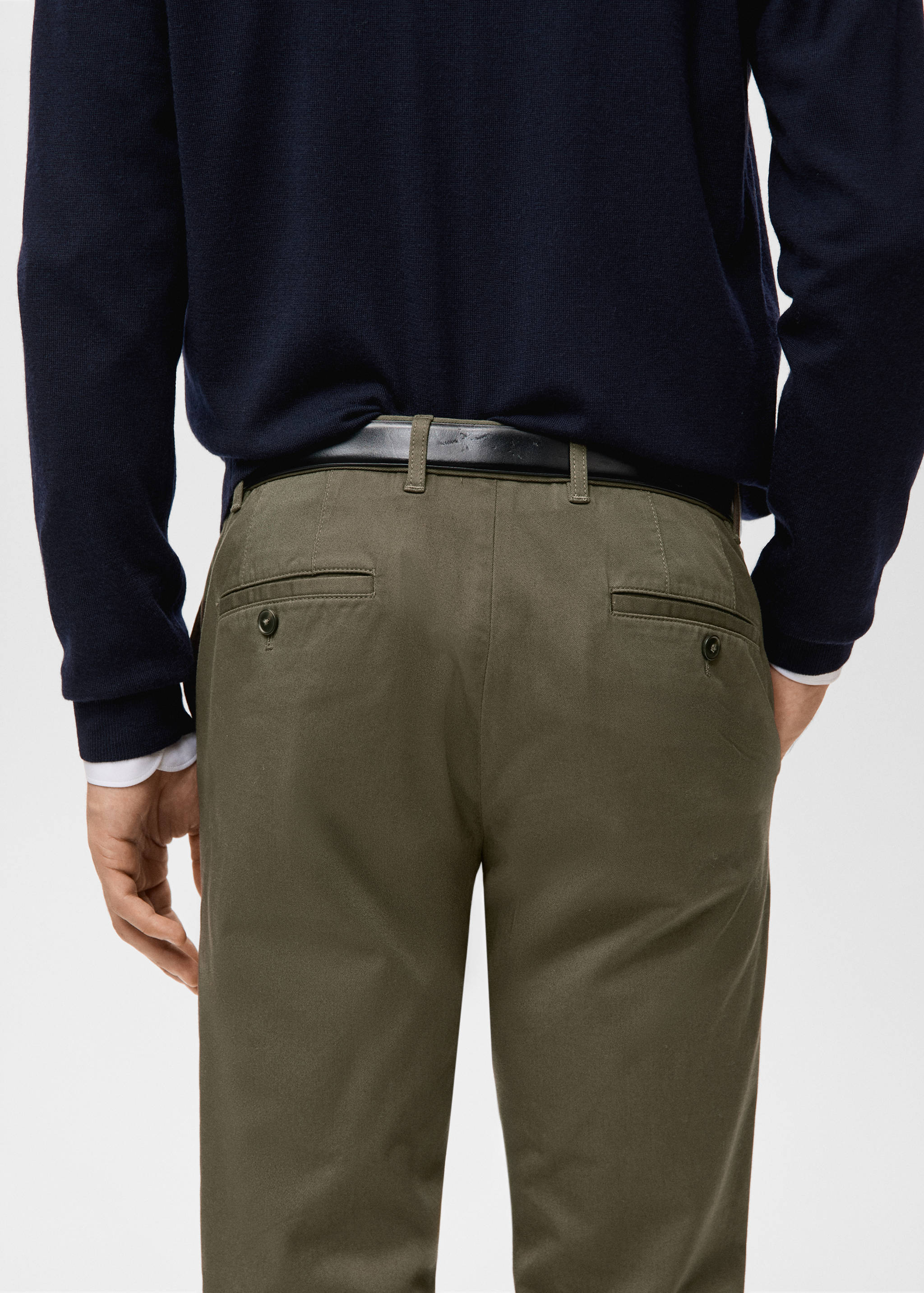 Olive green trousers with back welt pockets and a black leather belt.