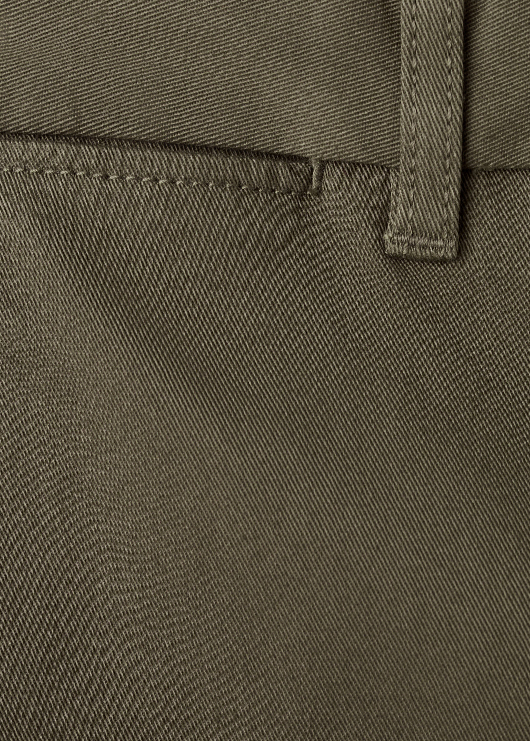 Close-up of olive green trousers fabric showing twill weave.