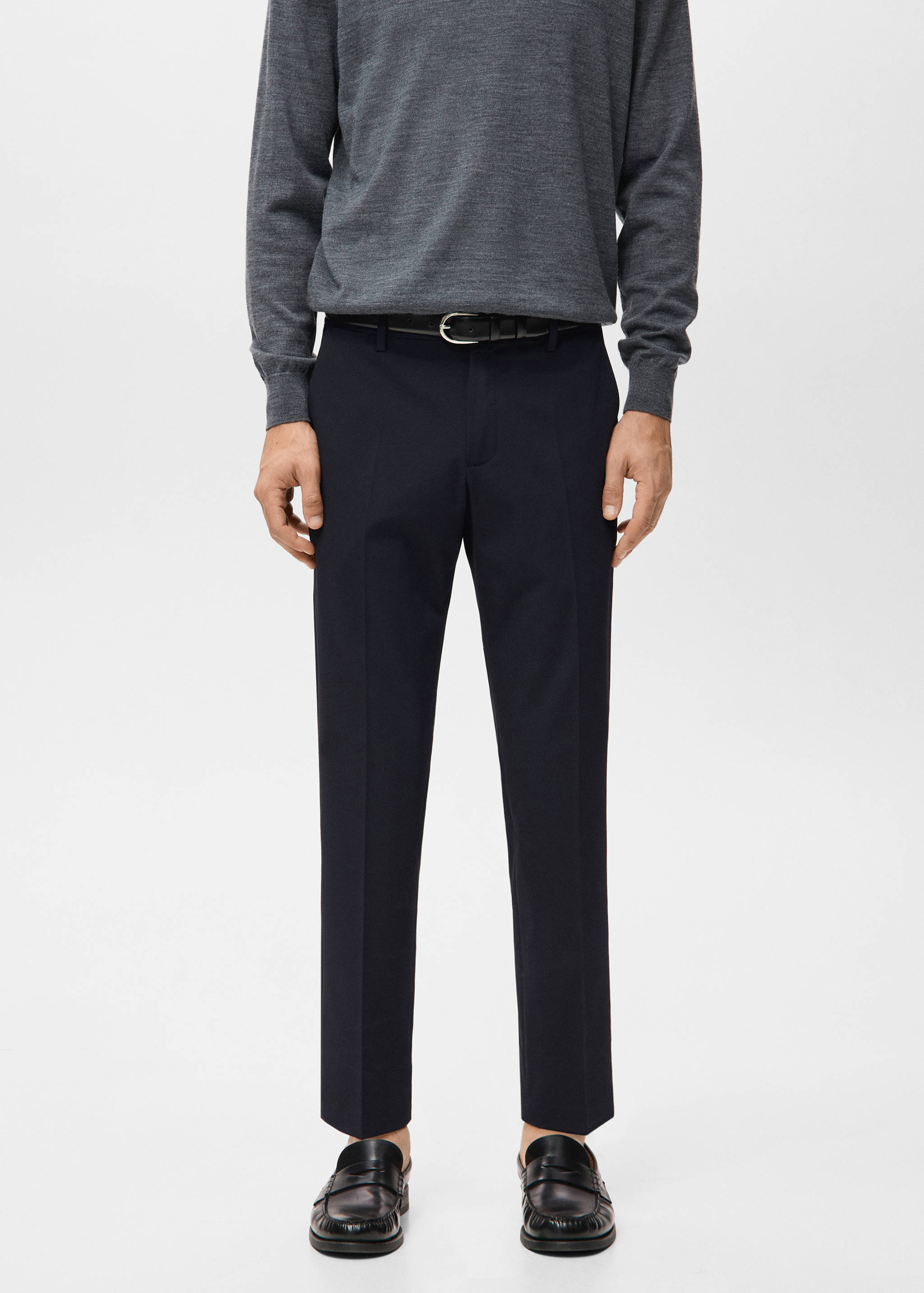 Navy blue trousers with belt loops and creases, styled with a black leather belt.