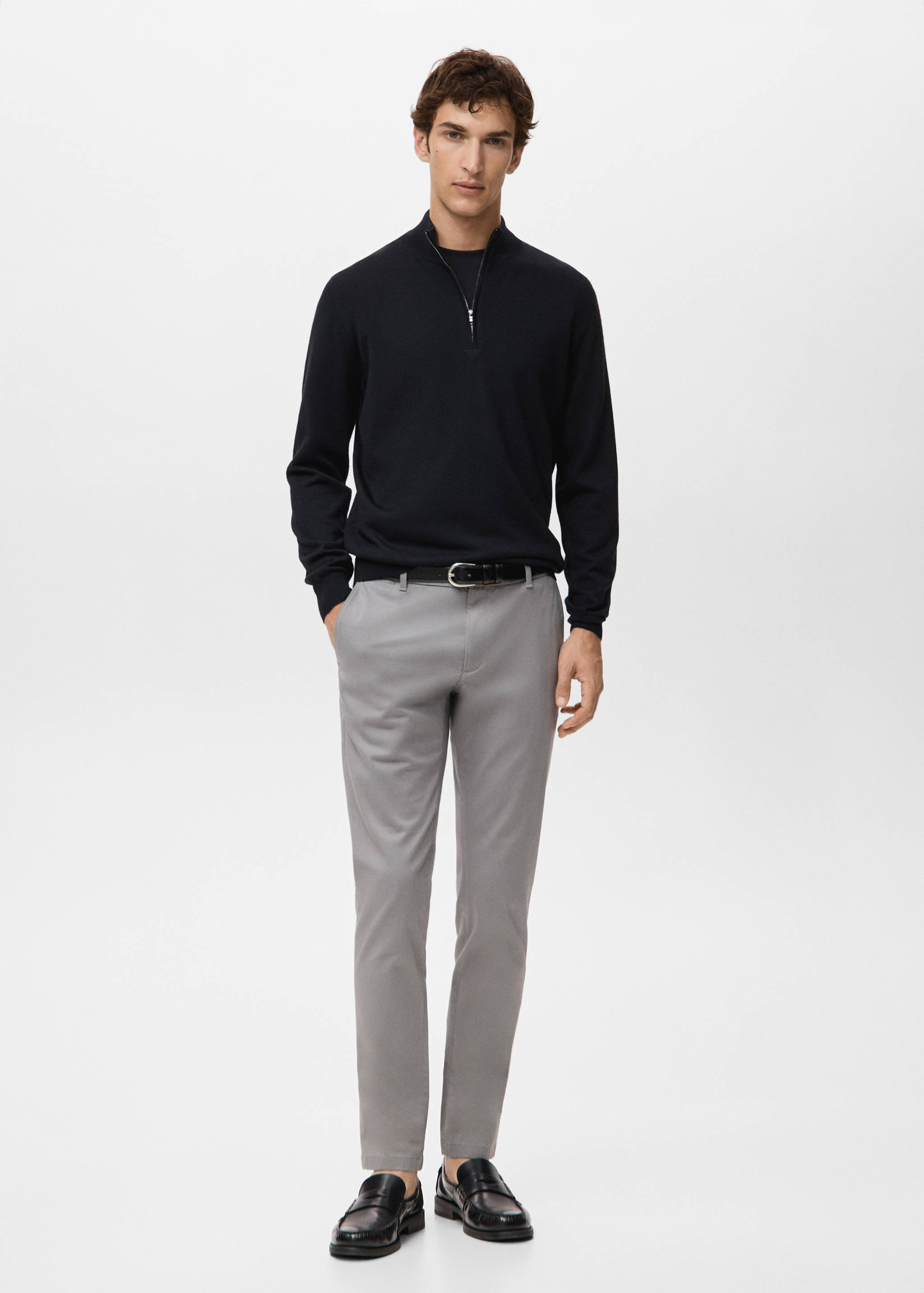 Grey trousers worn with a black half-zip sweater and belt.