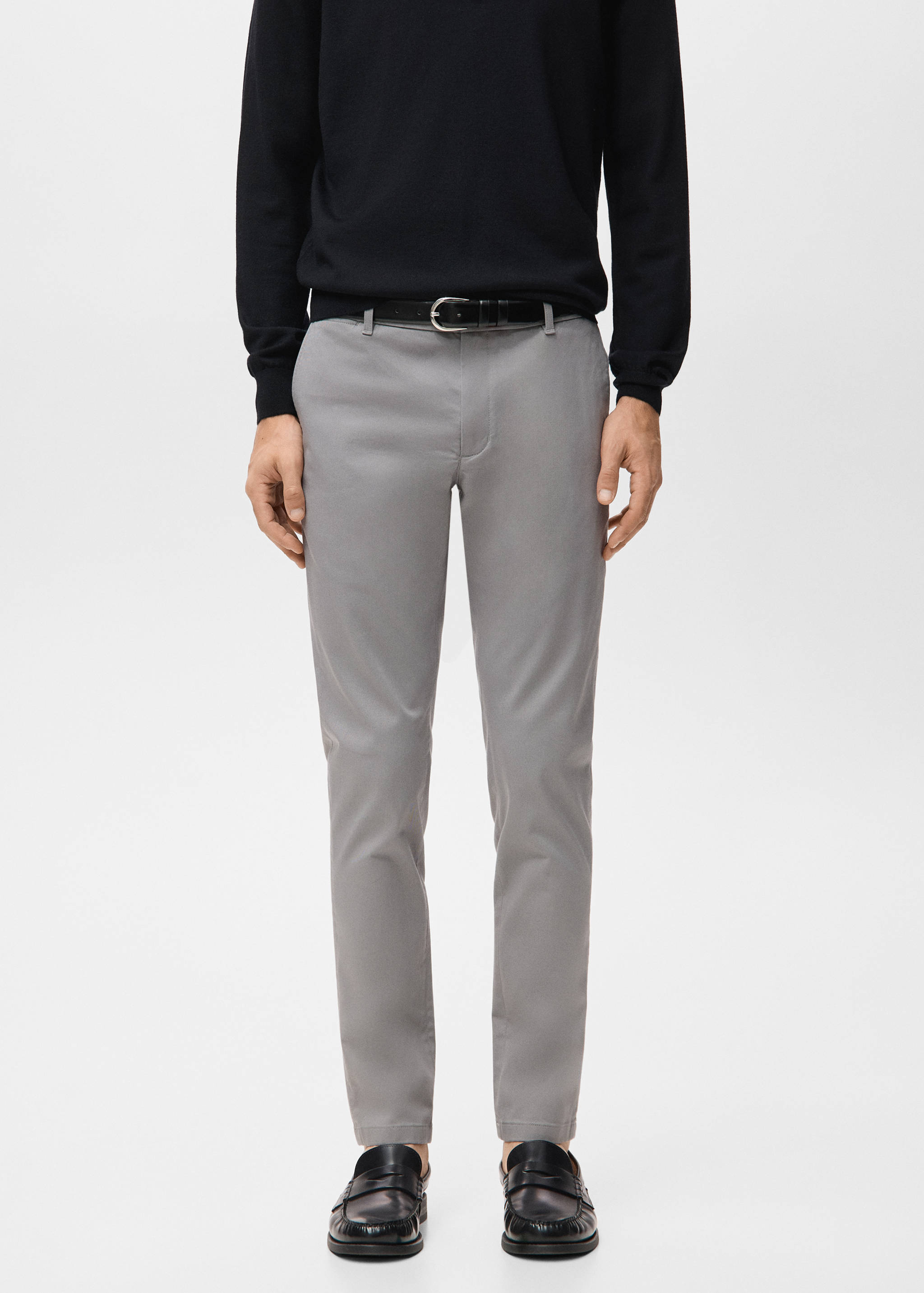 Grey slim-fit trousers worn with a black belt.