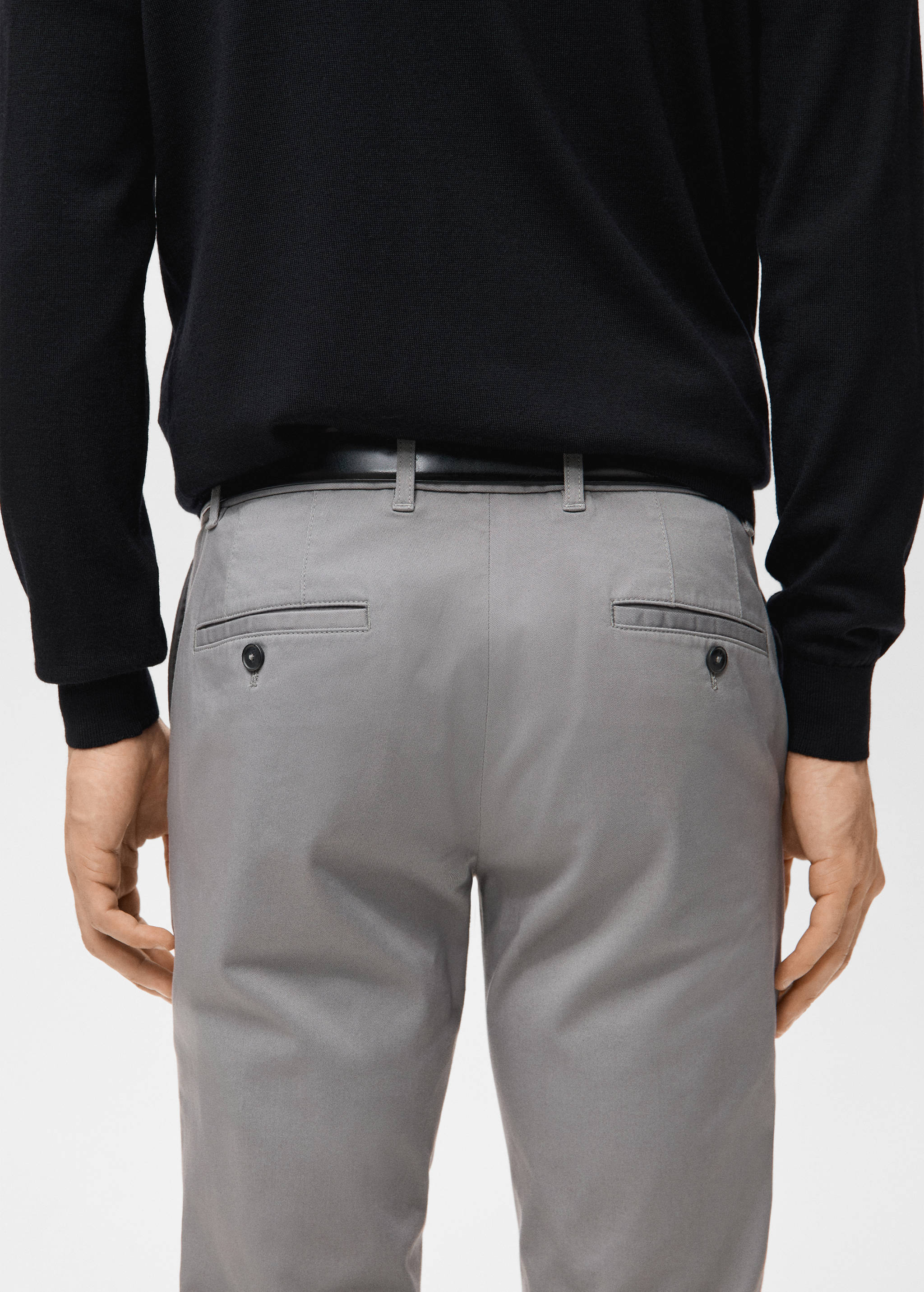 Grey trousers with rear buttoned welt pockets, back view.