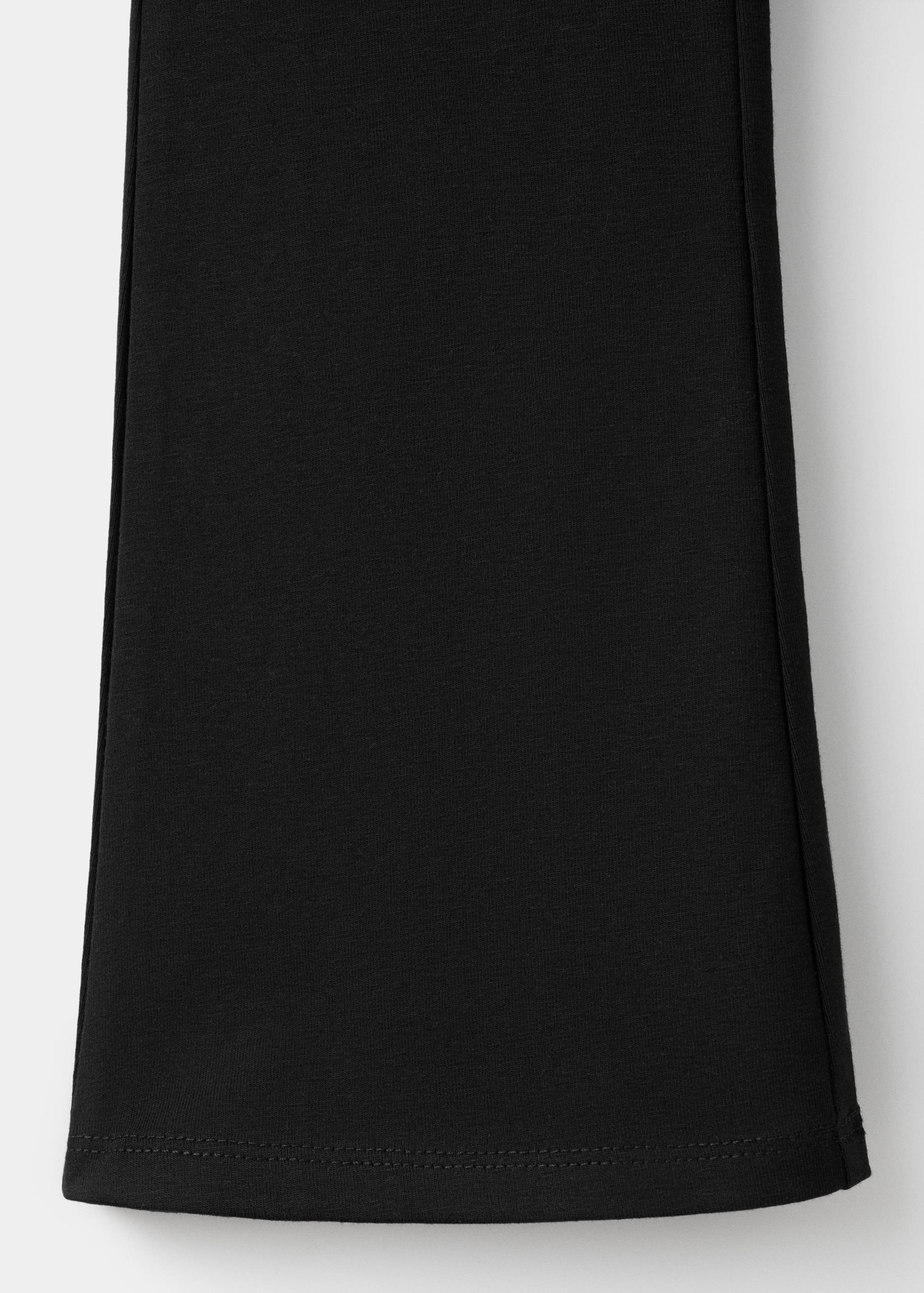 Close-up of black kids leggings fabric and hem.