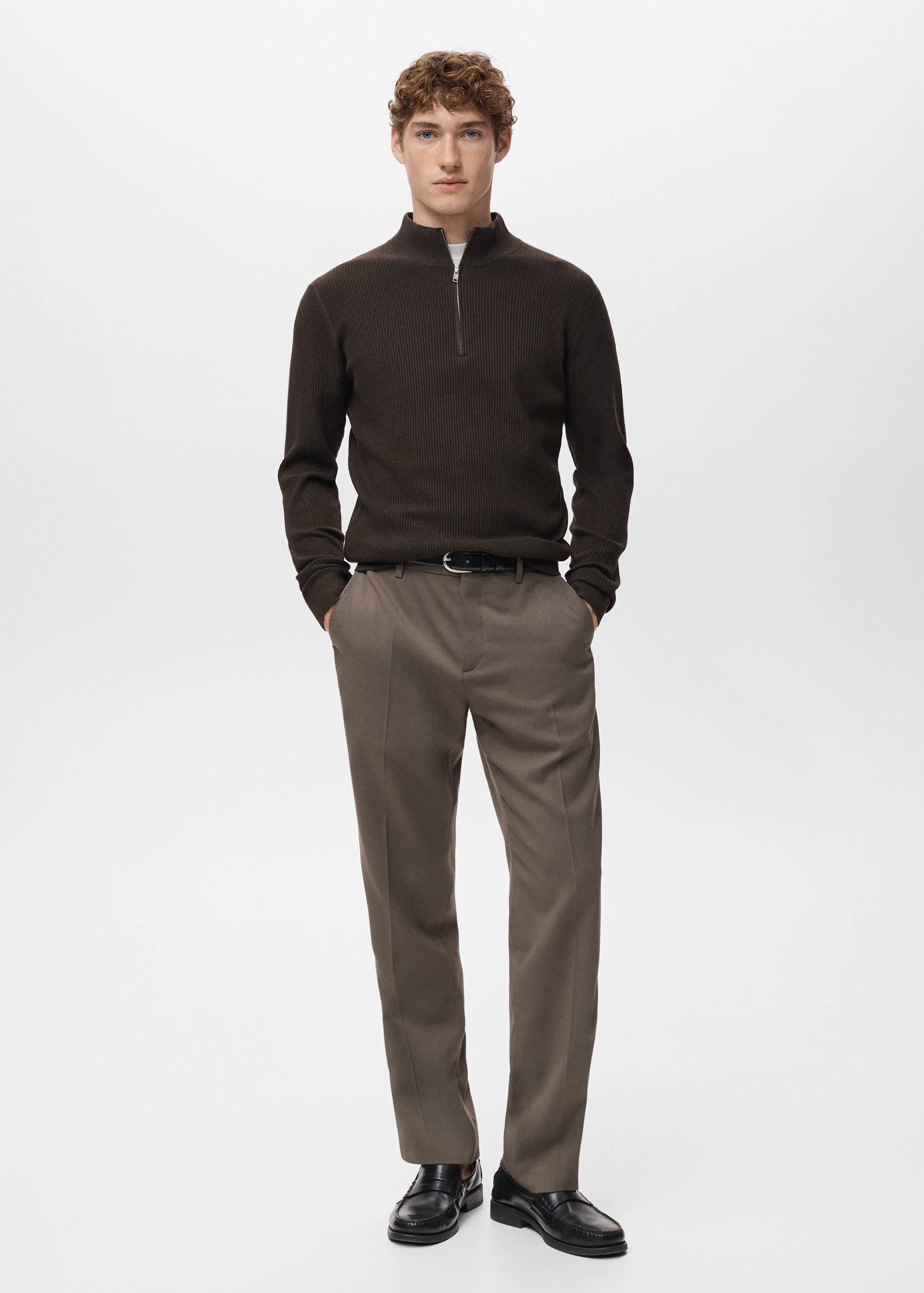 Dark brown ribbed zip-neck jersey with a high collar, worn with tailored trousers.