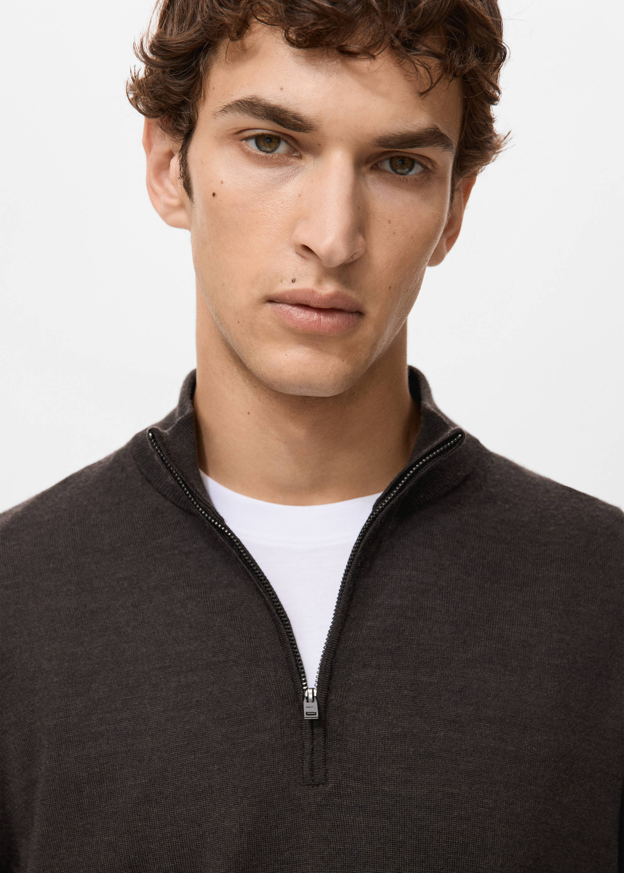 Close-up of a dark brown knit jersey with a zip-collar neckline.