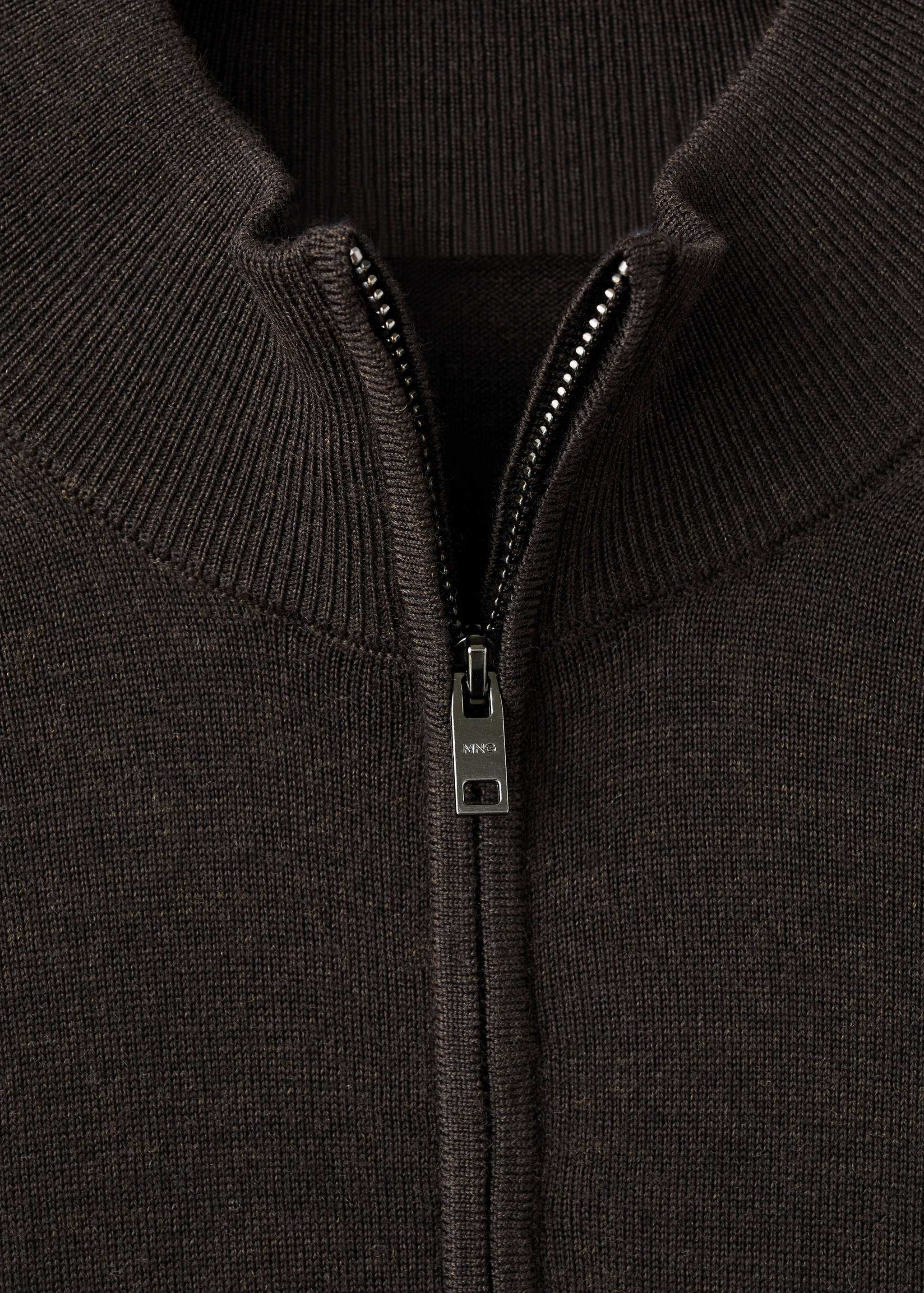 Close-up of a dark brown men's knitted jersey with a ribbed high neck and half-zip.