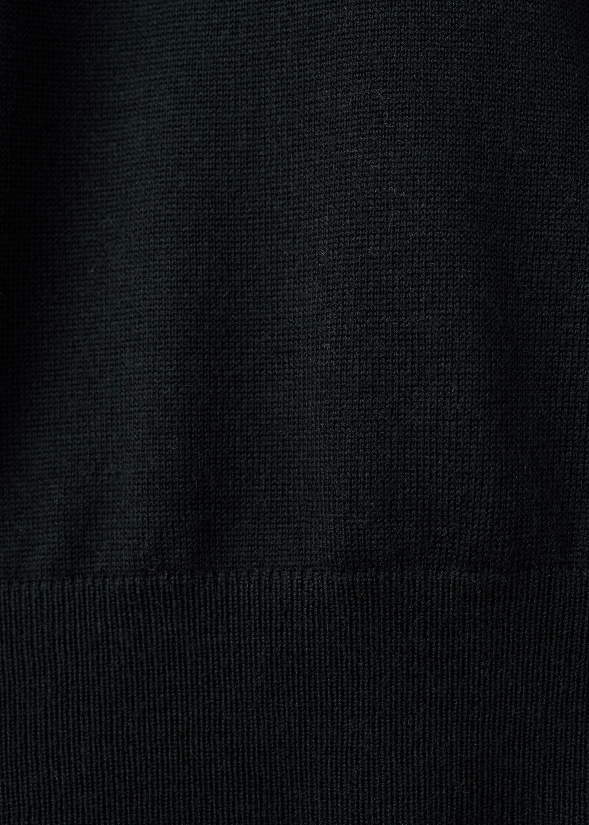 Close-up of the black knit fabric and ribbed hem on a men's jersey.