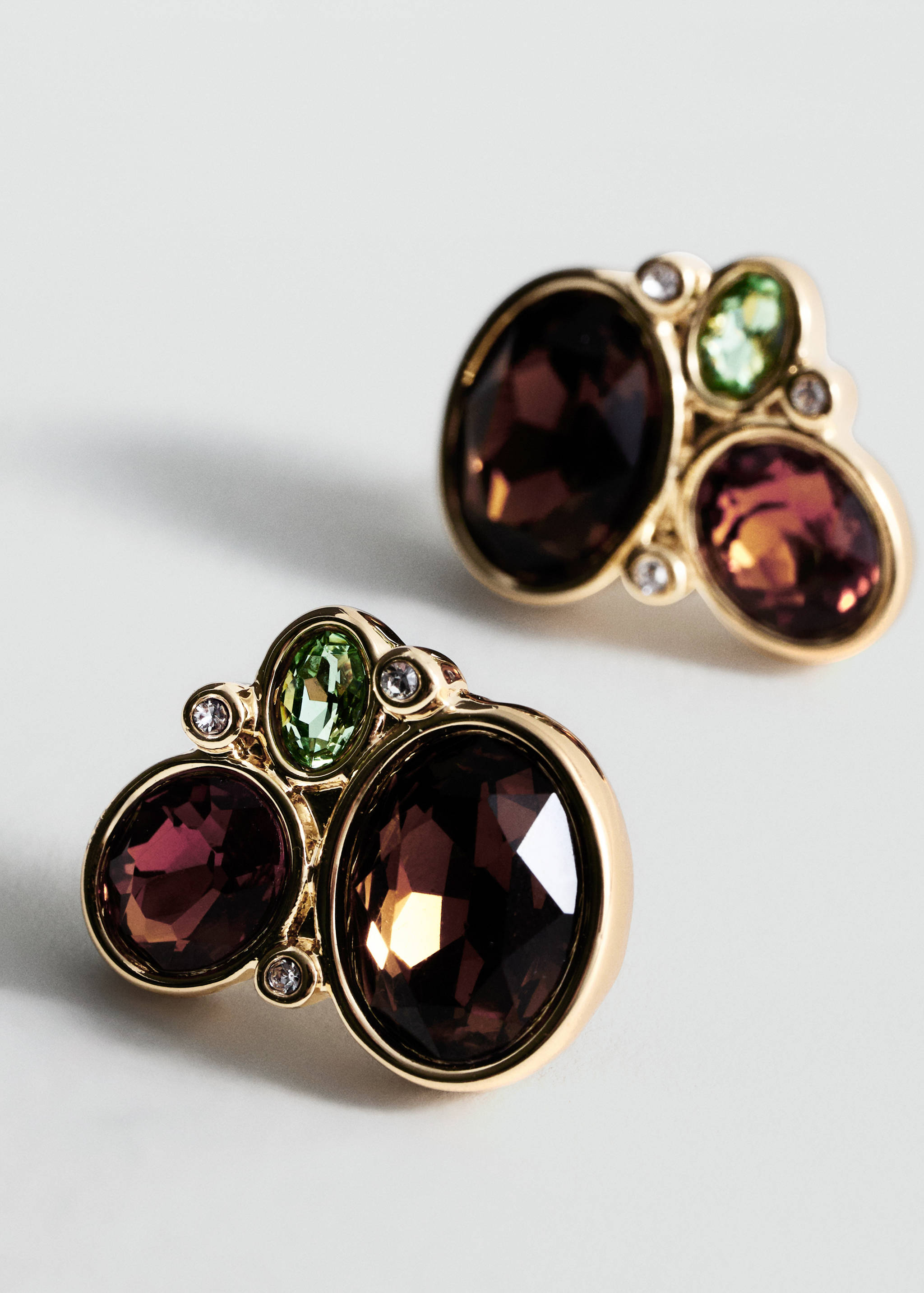 Gold-tone earrings with clusters of faceted purple and green crystals.