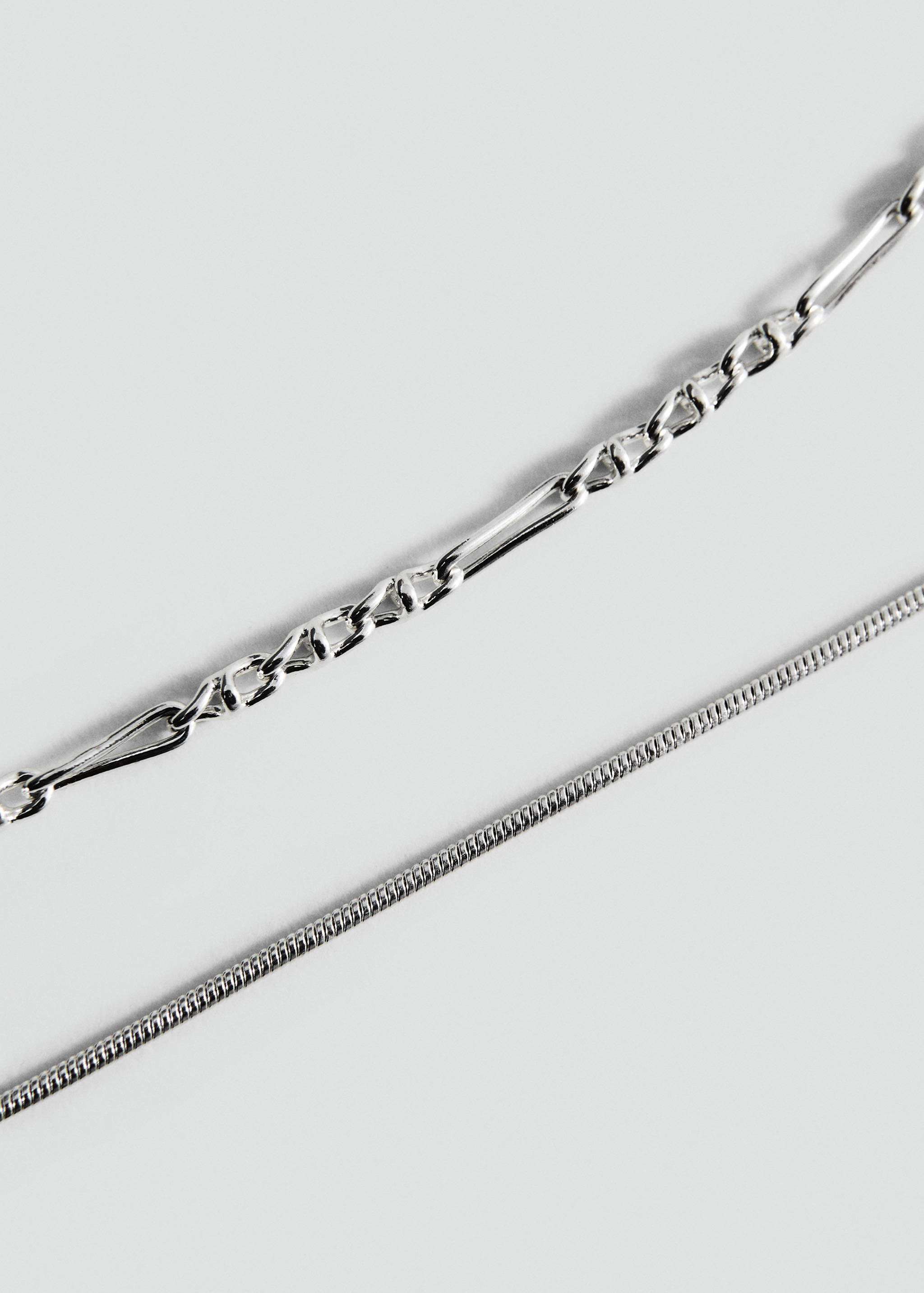 Close-up of a silver-toned multi-strand chain necklace set.
