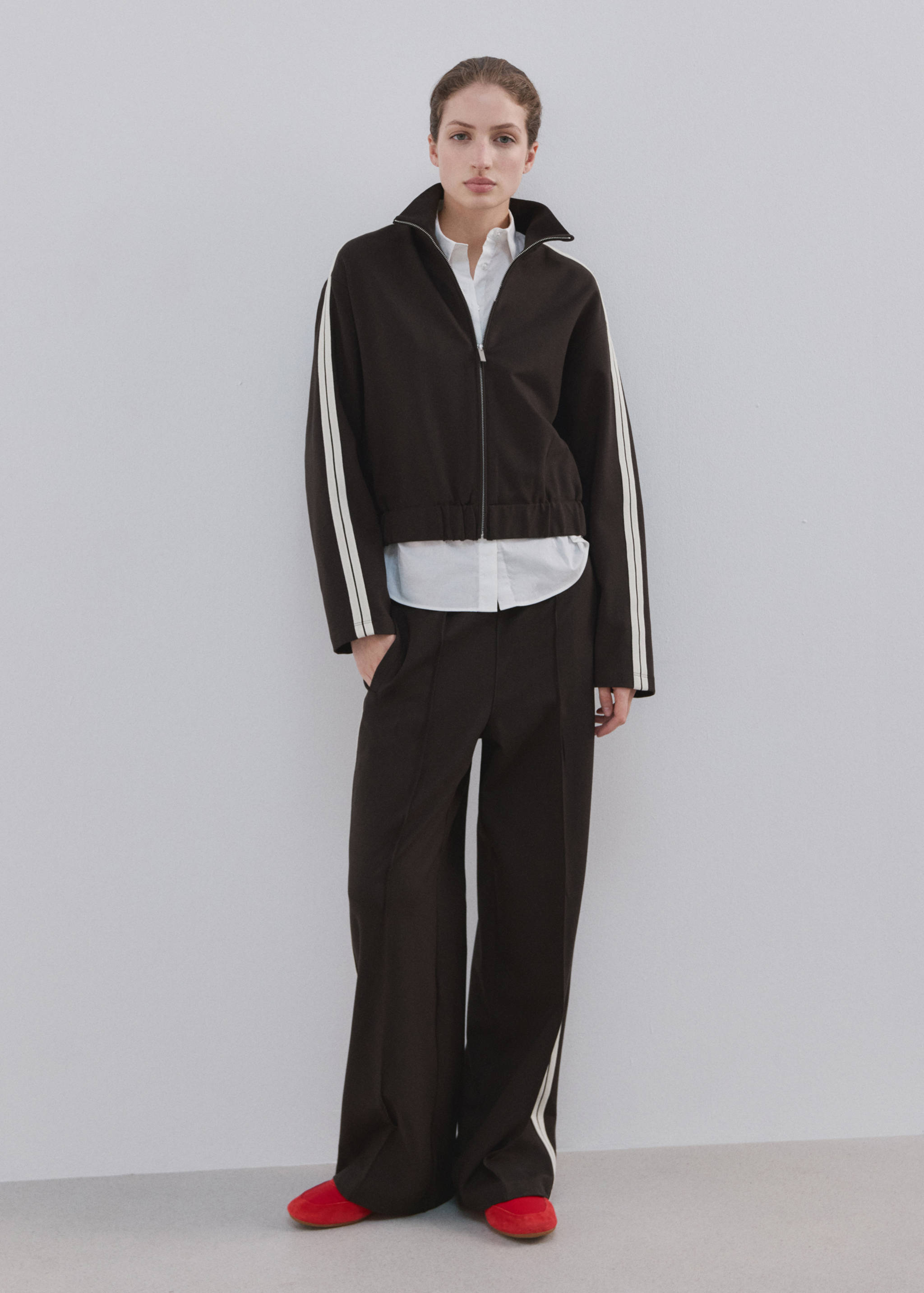 Dark brown zip-up sweatshirt with a high neck and white side stripes.