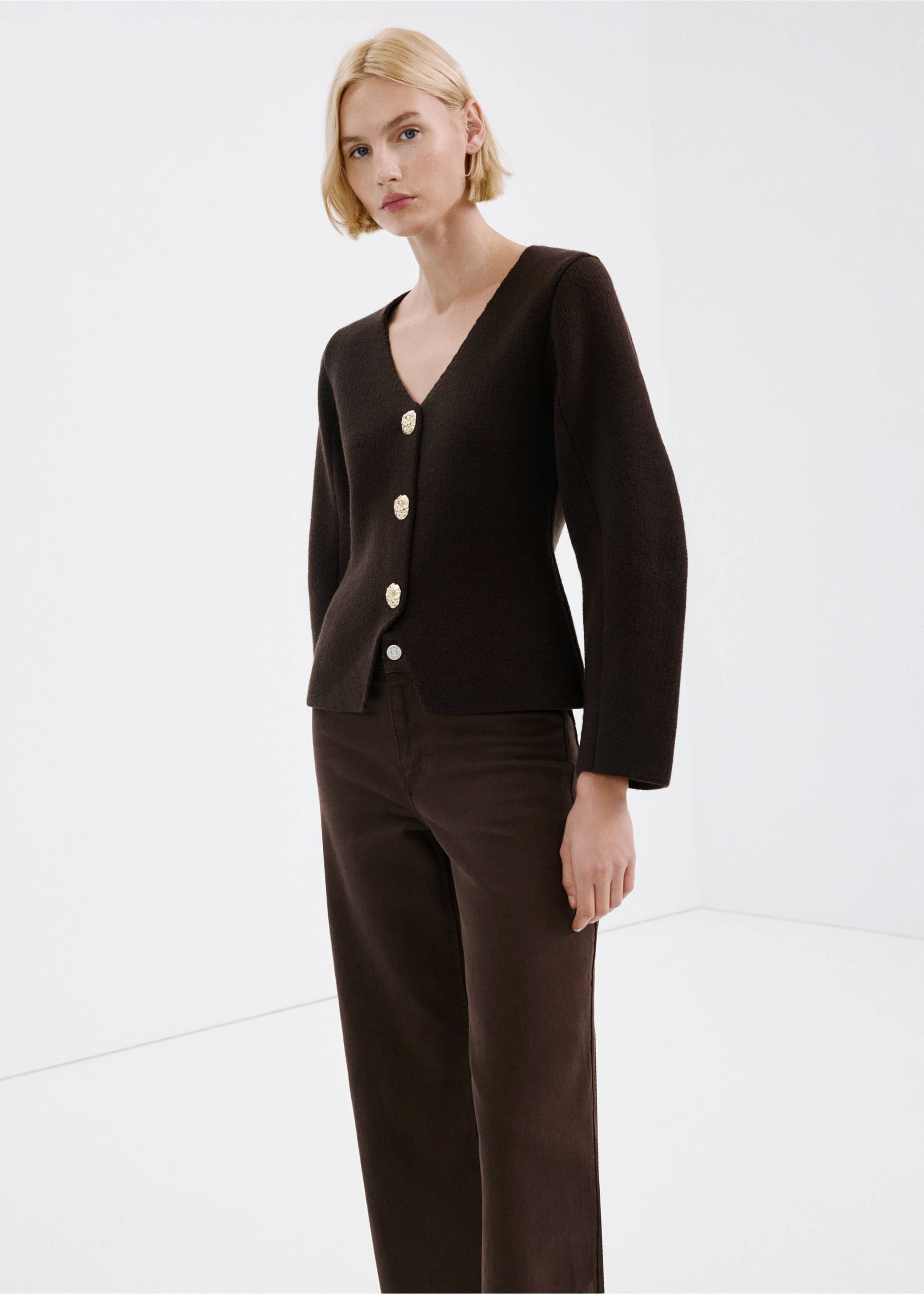 Dark brown knitted cardigan with V-neck and ornate gold buttons, worn with brown trousers., Chocolate. Ref: 27043342-00.