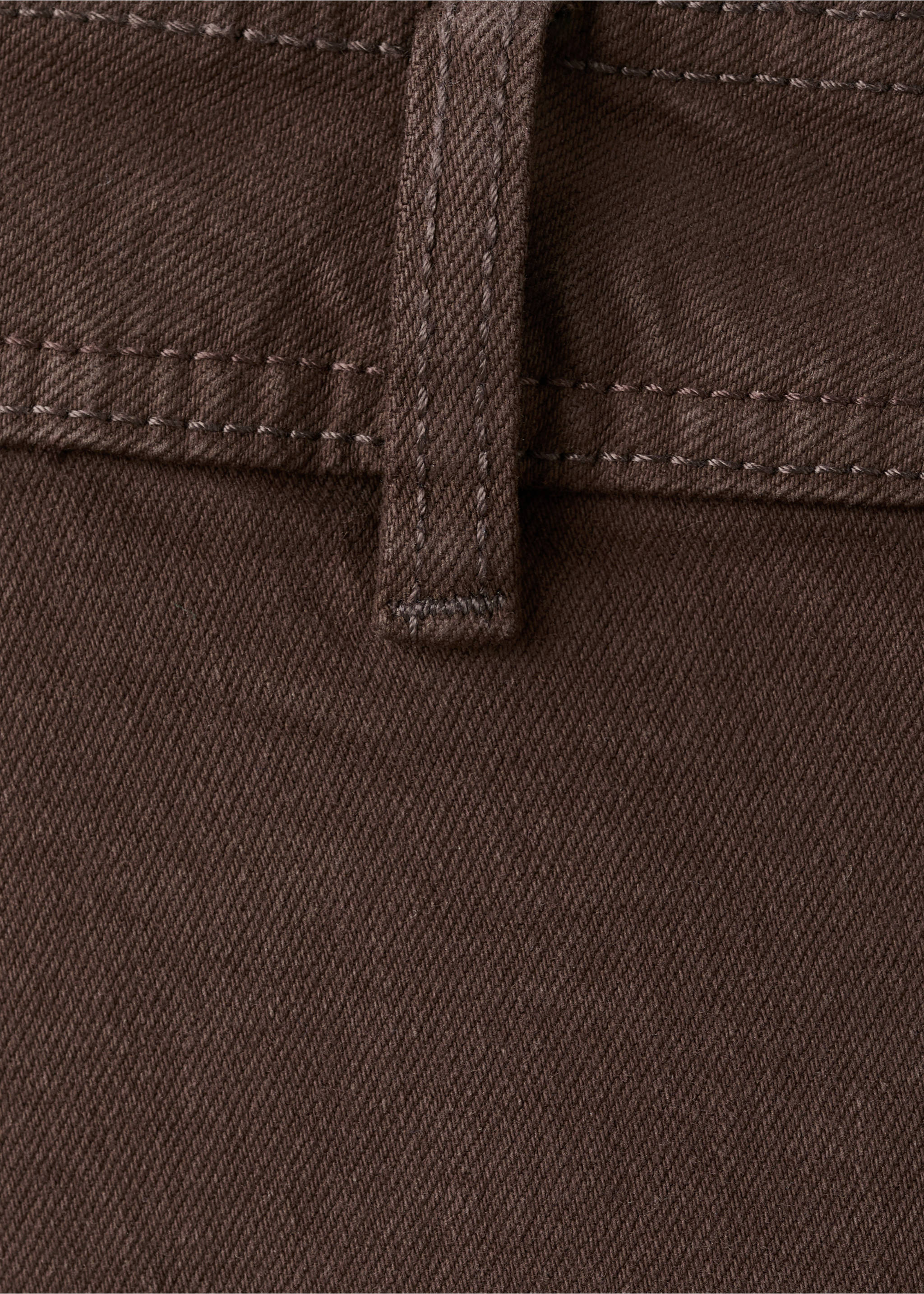 Close-up of dark brown denim fabric and waistband detail., Chocolate. Ref: 27043342-00.