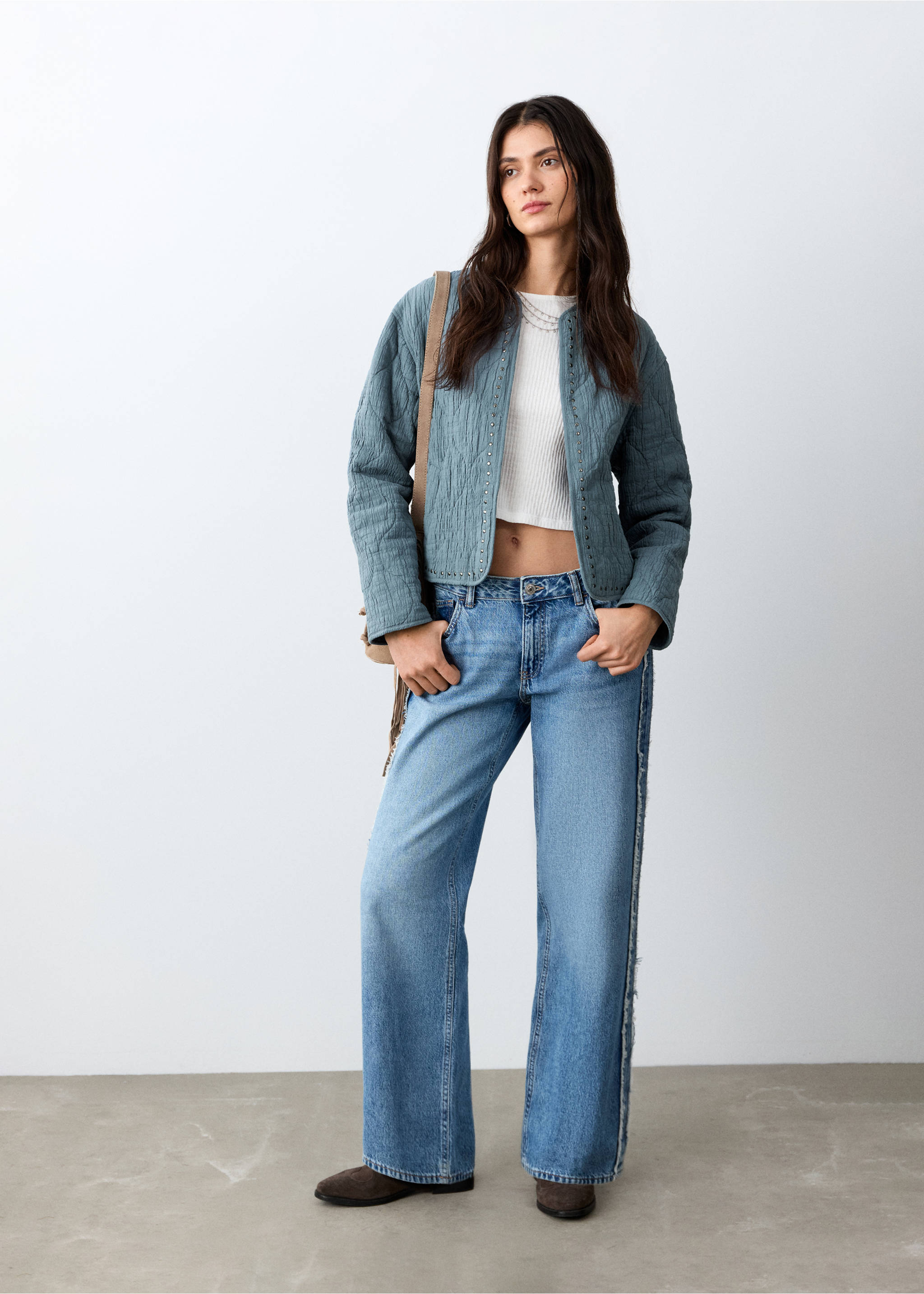 Teal quilted jacket with studded trim, worn over a white crop top and blue denim trousers., Petrol Blue. Ref: 27045156-00.