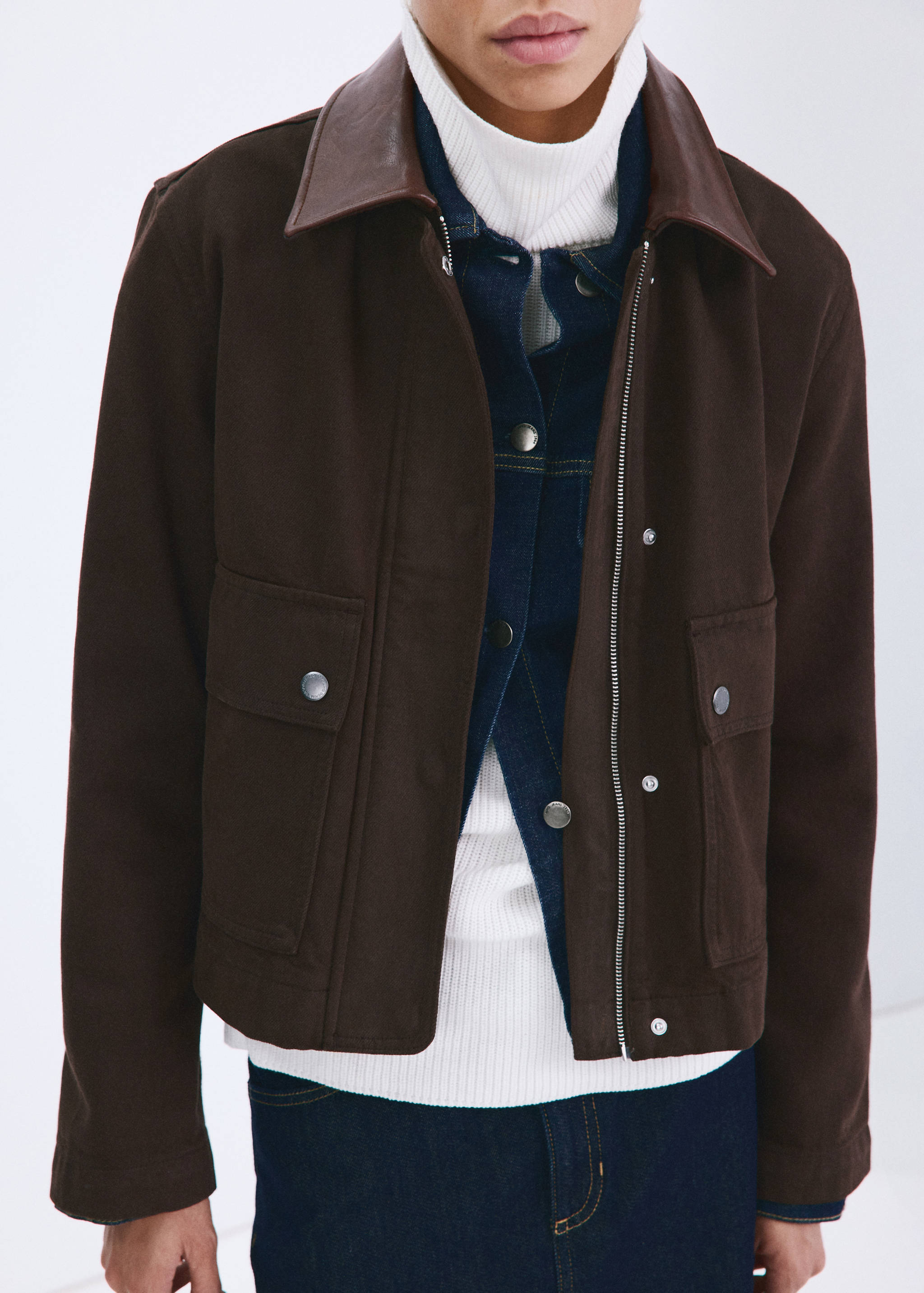Brown cropped jacket with front pockets and collar, worn layered.