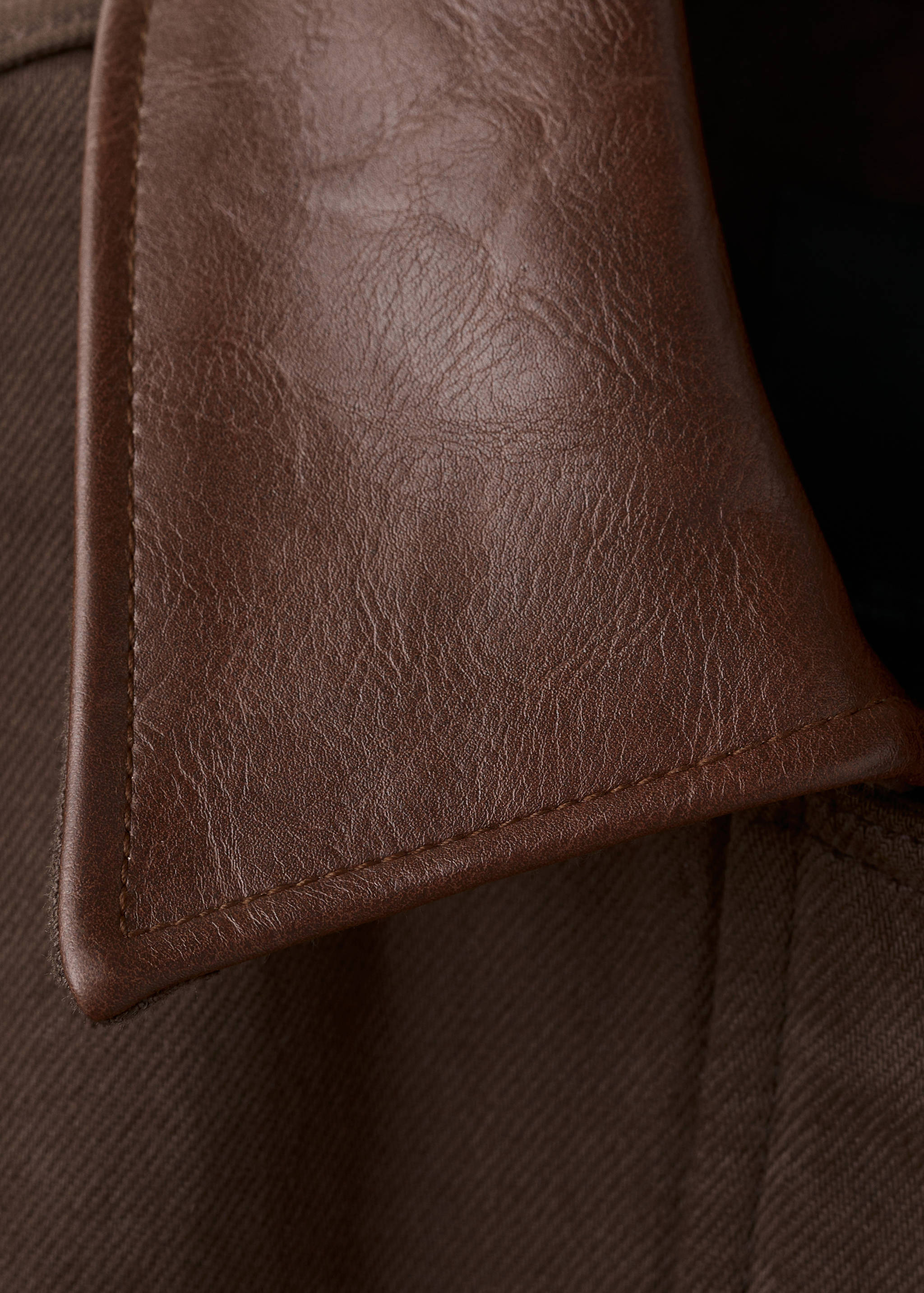 Brown jacket collar detail showing faux-leather texture and topstitching.