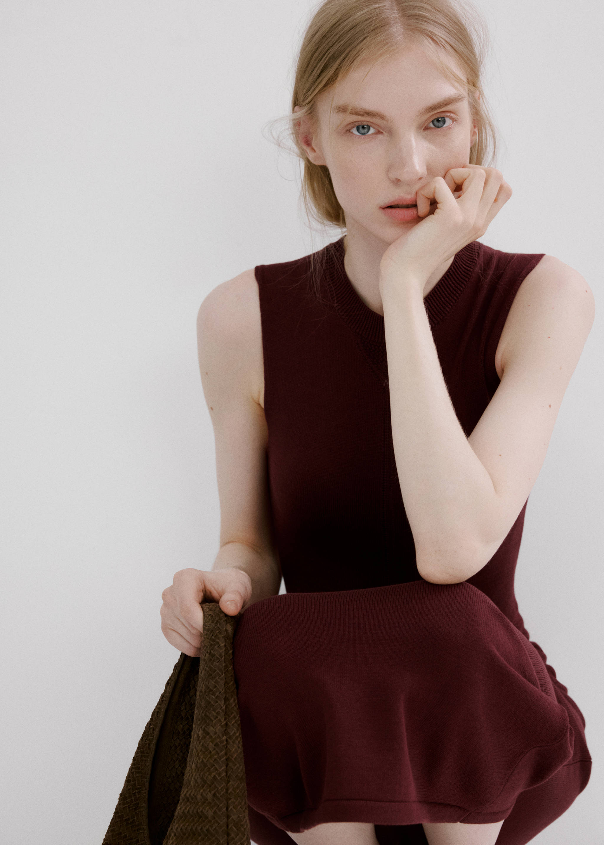 Burgundy sleeveless knit dress with a ribbed round neckline and form-fitting silhouette.