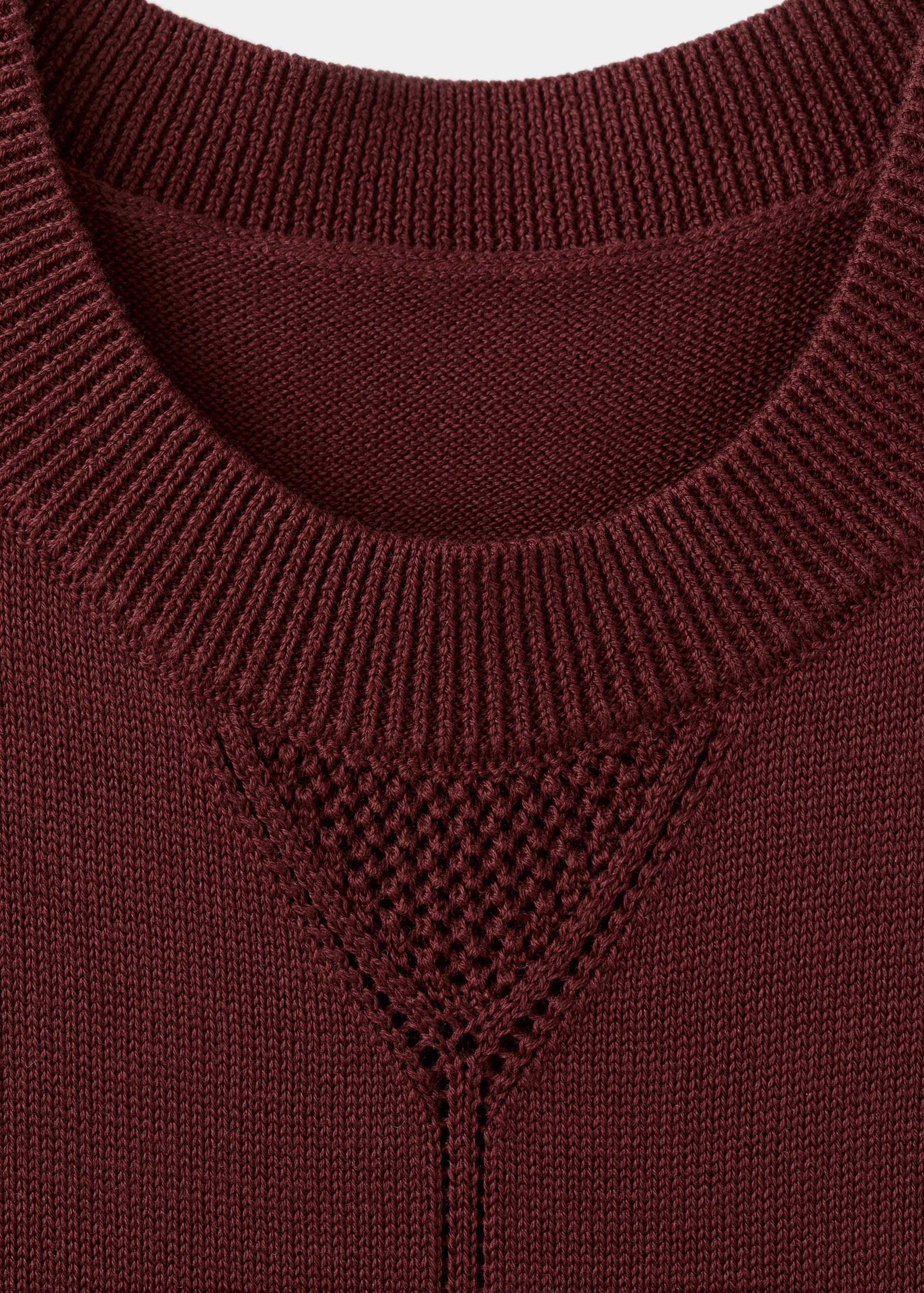 Burgundy knit dress neckline detail with ribbed collar and triangular openwork panel.