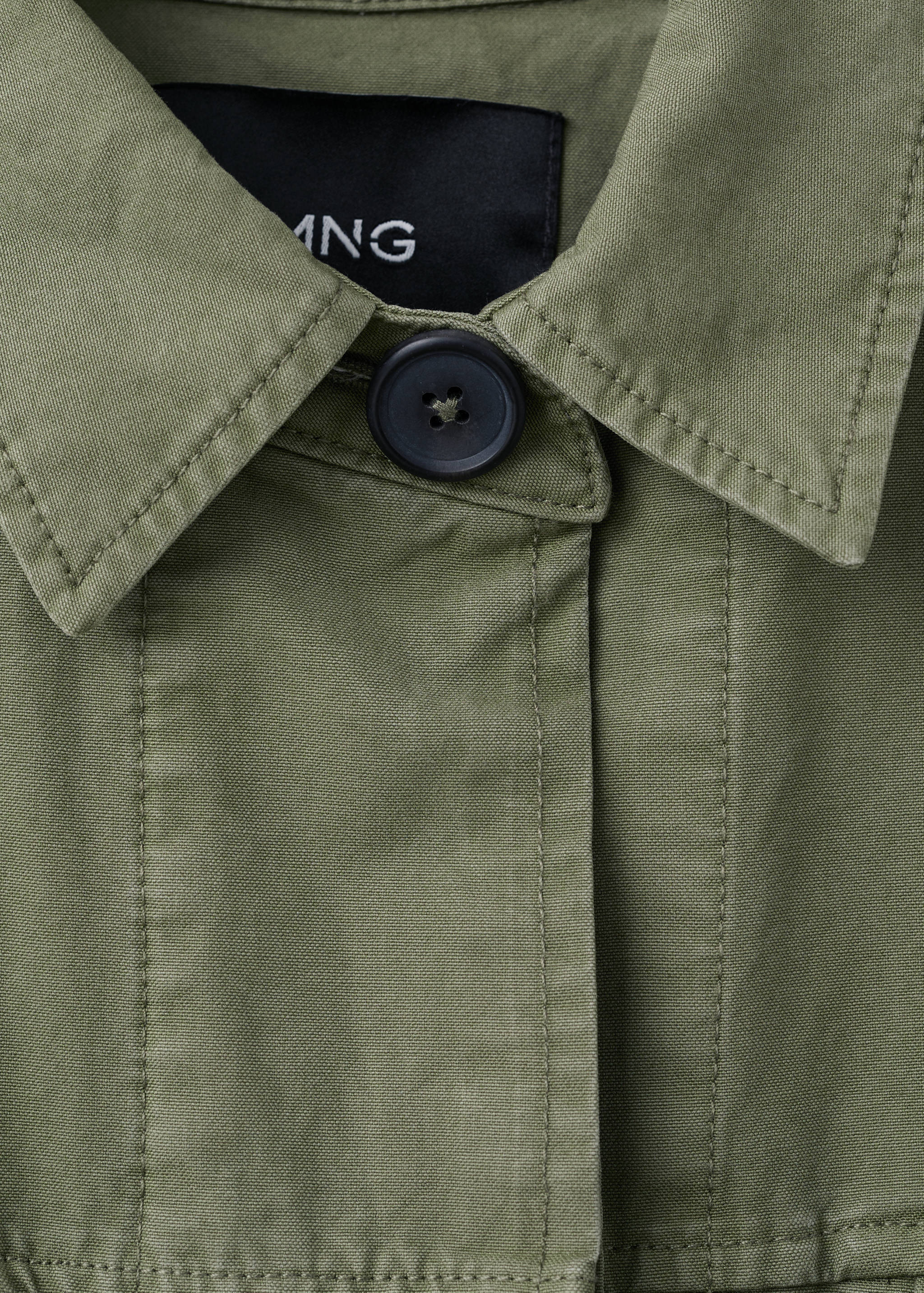 Detalle del cuello y los botones de la parka verde oliva.