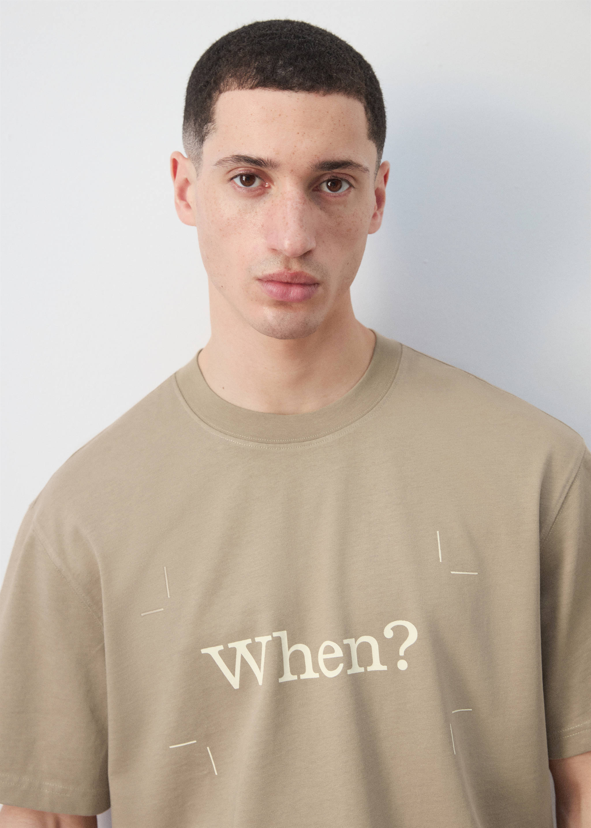 Khaki green short-sleeved t-shirt with a round neck and "When?" chest print.
