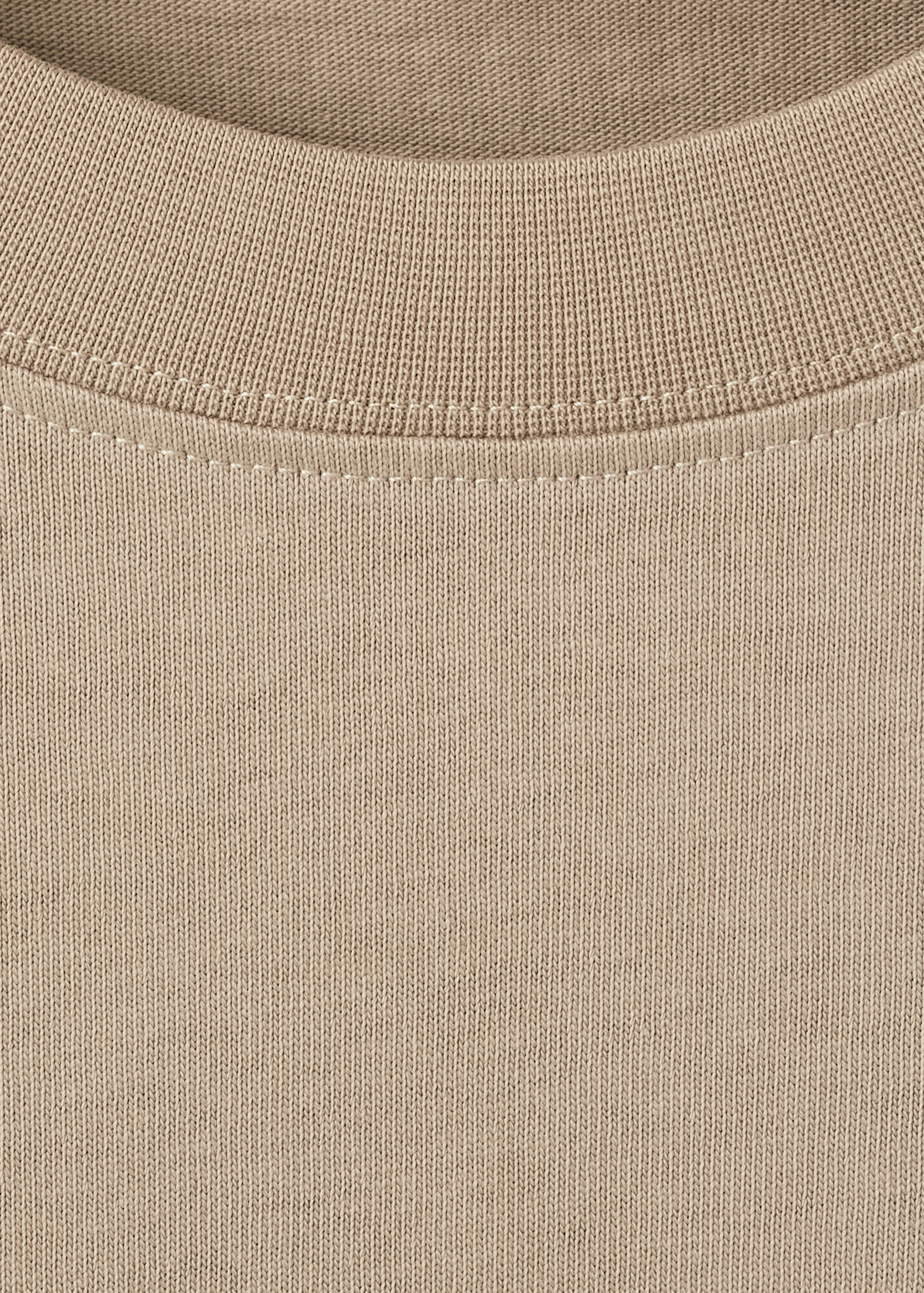 Beige t-shirt detail showing a ribbed crew neck and fine knit.