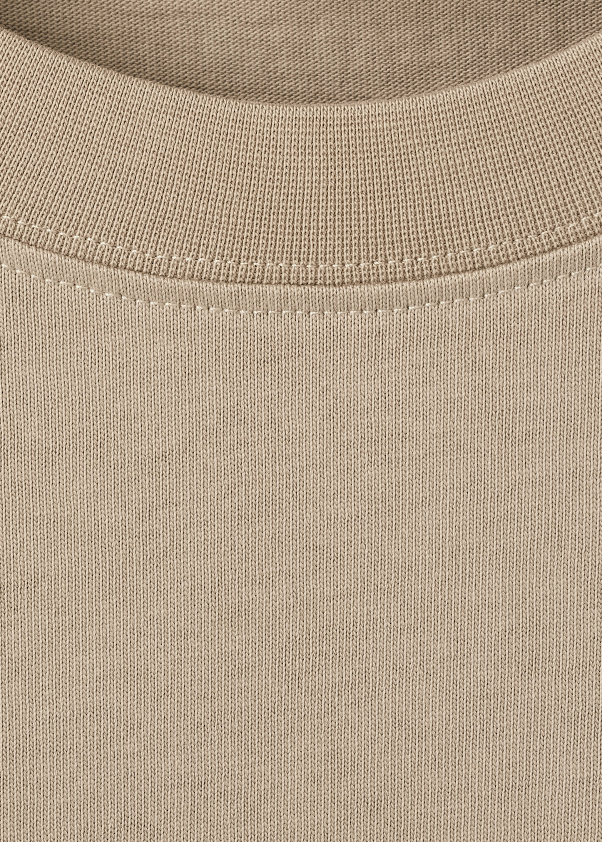 Close-up of a beige t-shirt with a ribbed crew neck.