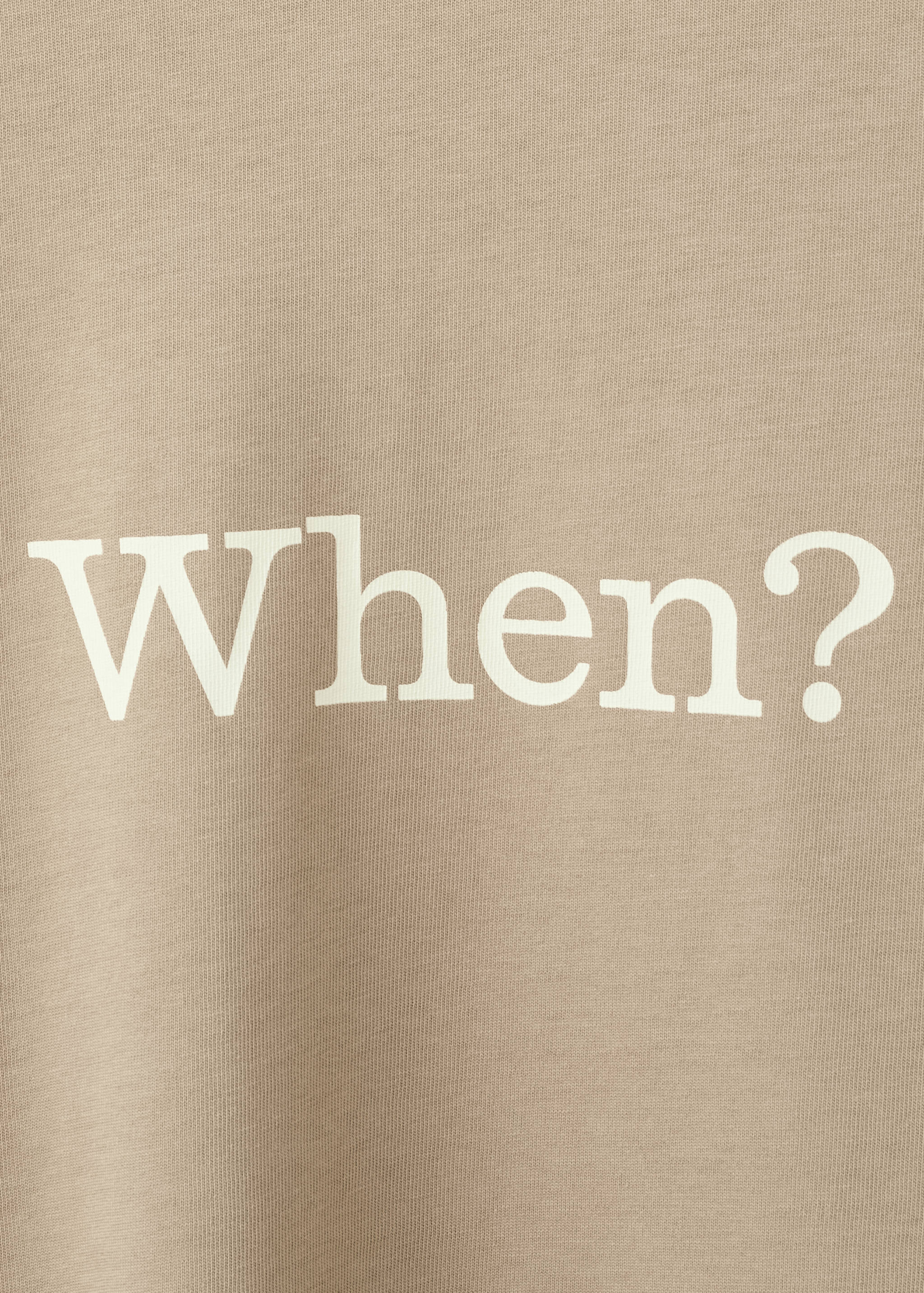 Beige t-shirt fabric detail with large white printed text 'When?'.