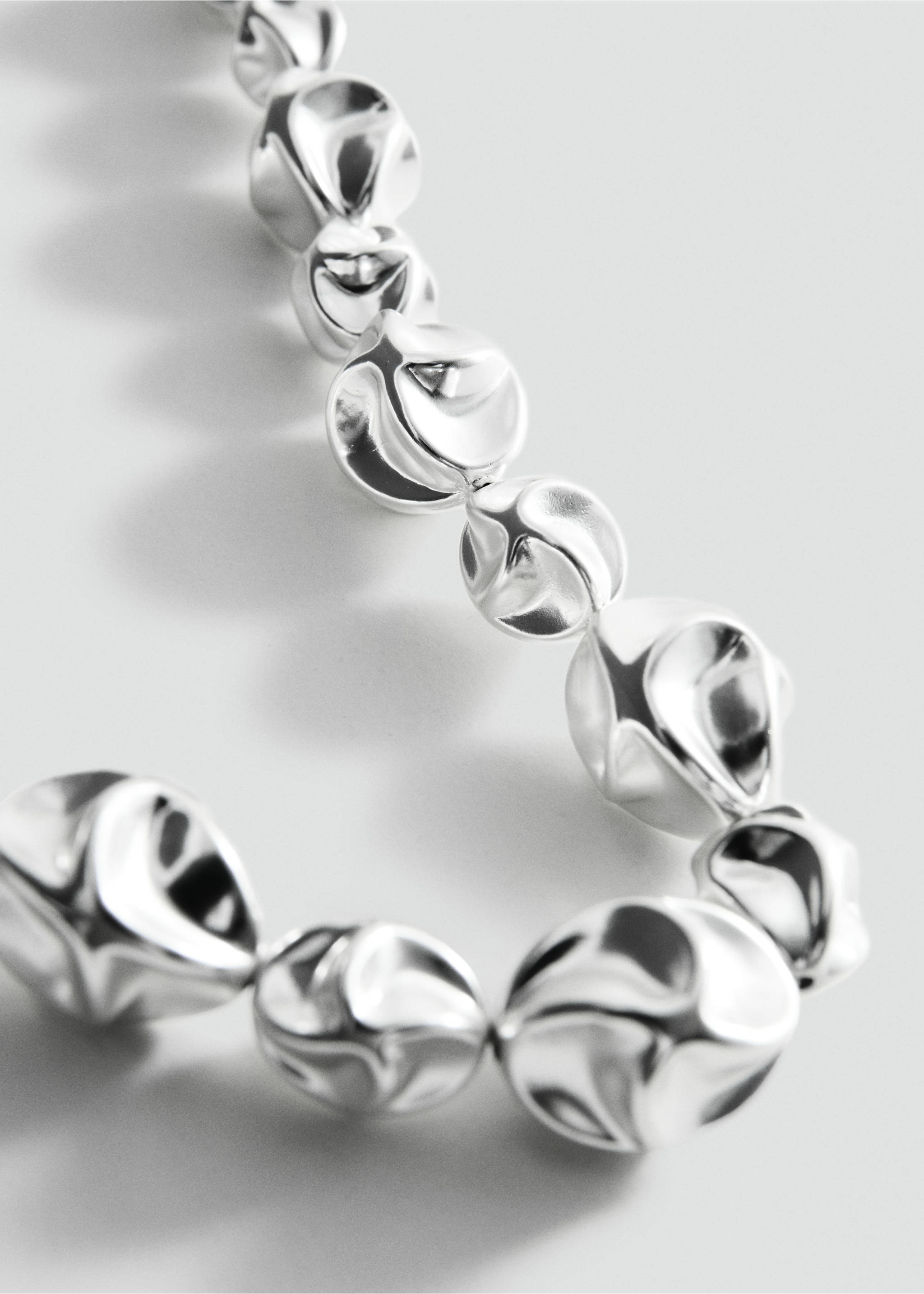 Silver necklace with irregular metallic beads, close-up view., Silver. Ref: 27047798-00.