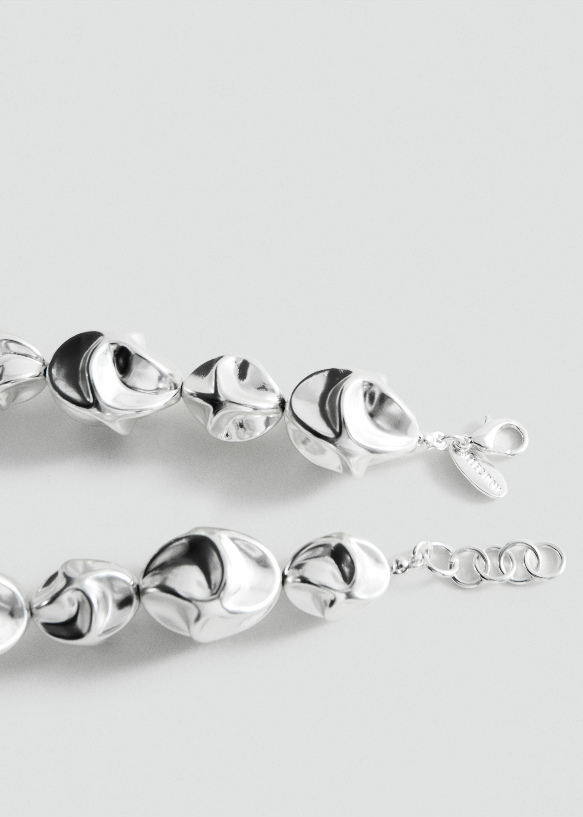 Close-up of a silver-coloured metallic necklace with irregular faceted beads., Silver. Ref: 27047798-00.