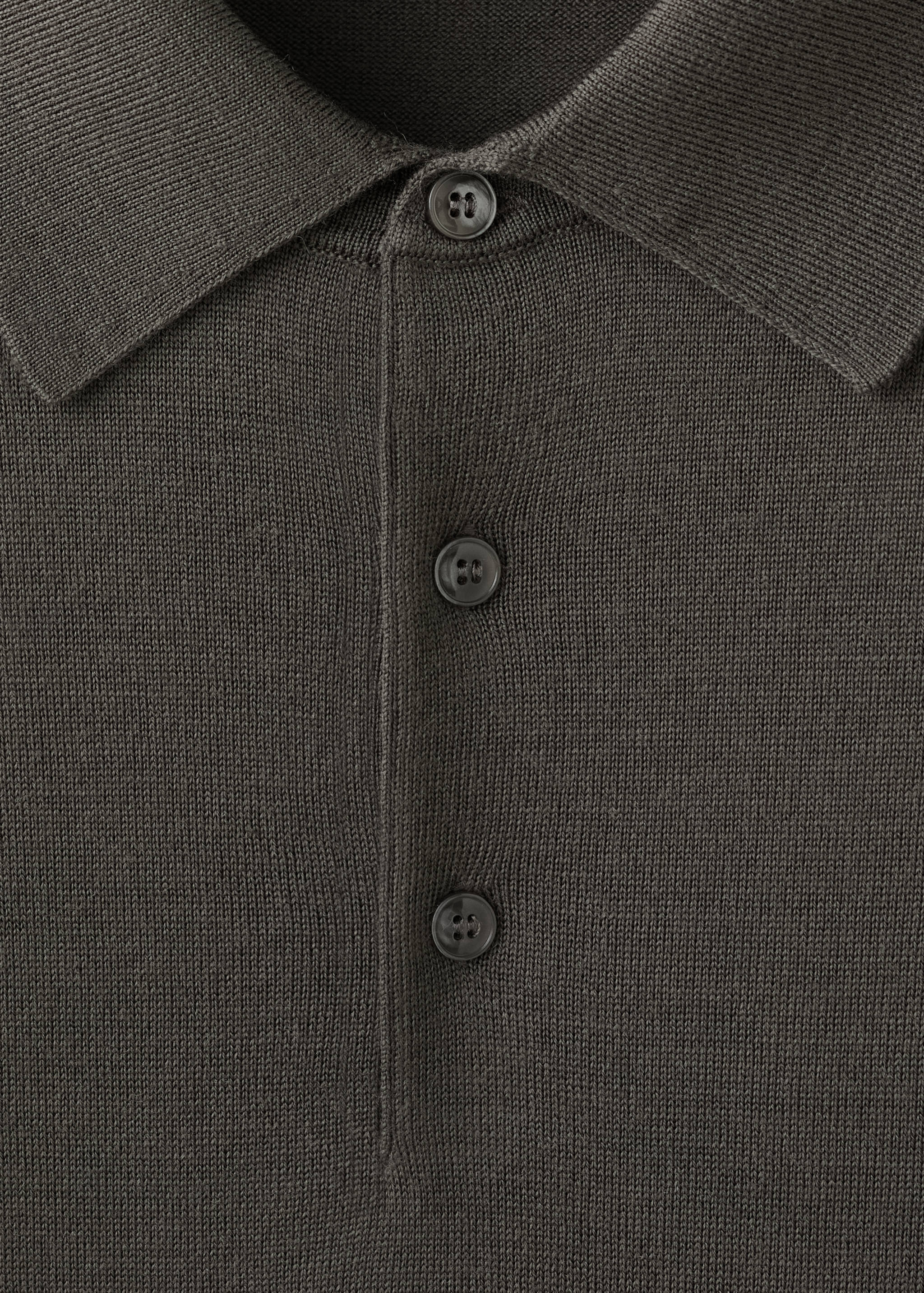 Close-up of a dark grey knit polo shirt collar and button placket.