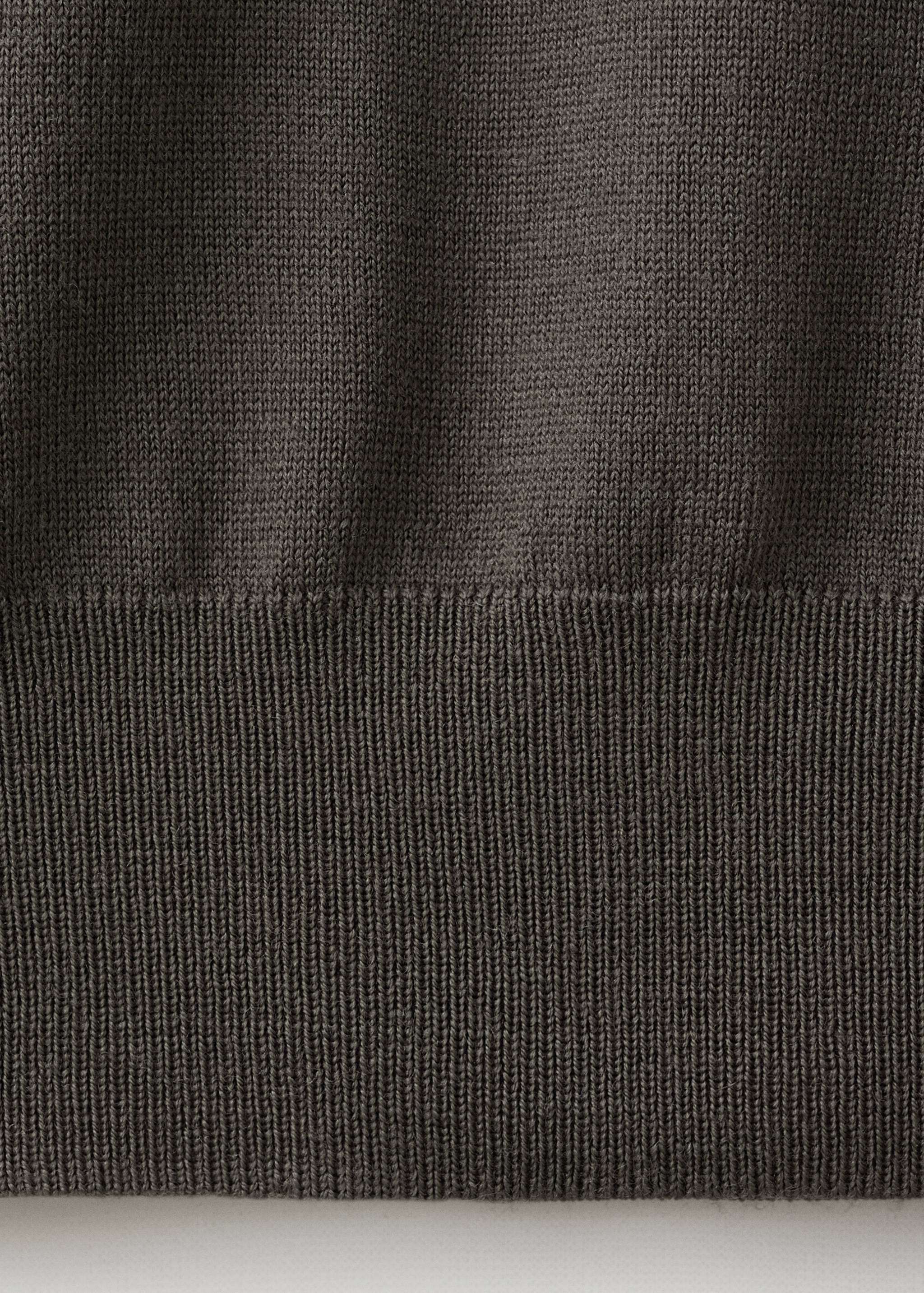 Dark grey polo knit fabric detail showing ribbed hem.