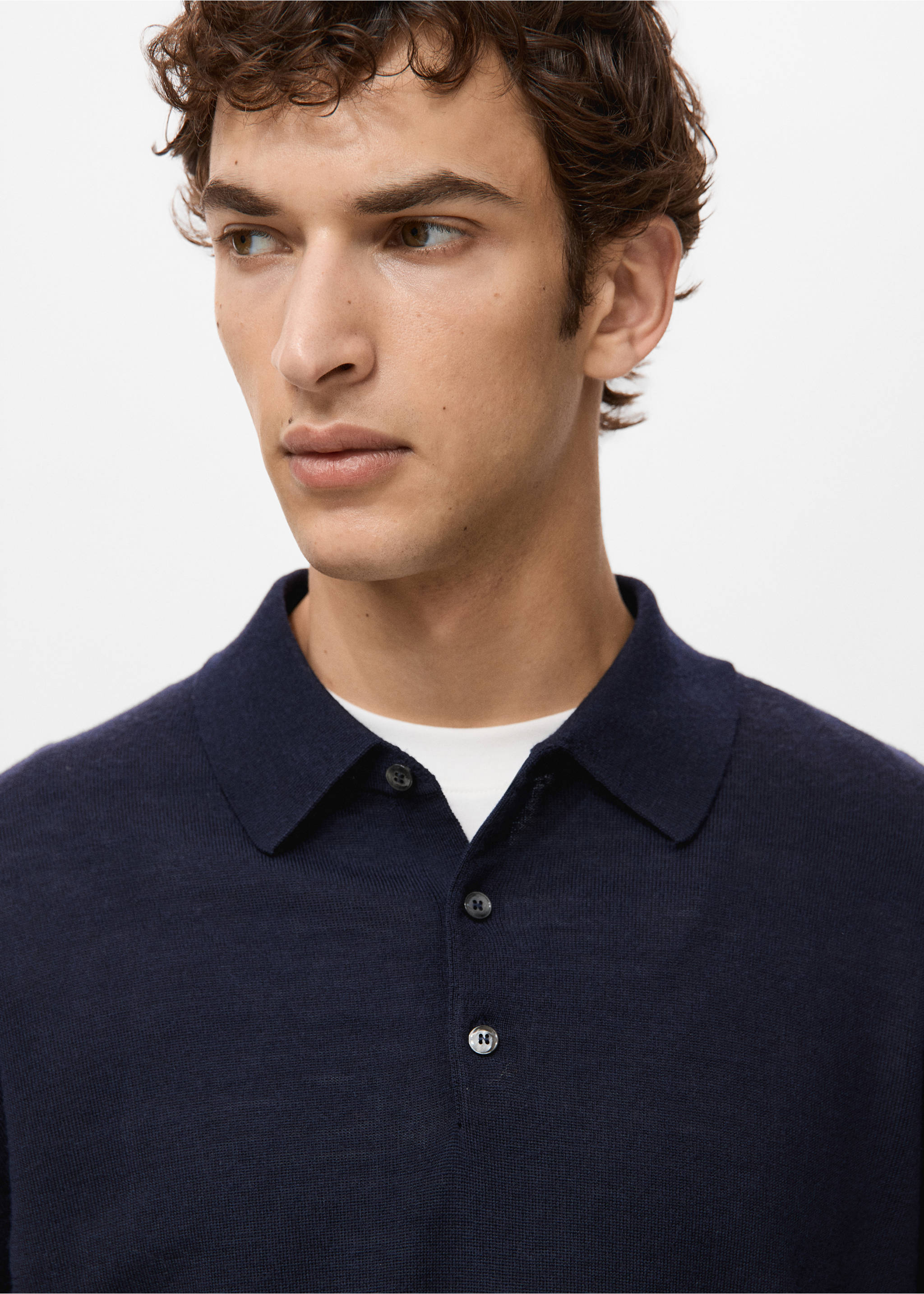 Close-up of a navy blue knit polo shirt with a classic collar and button placket., Navy. Ref: 27051283-00.